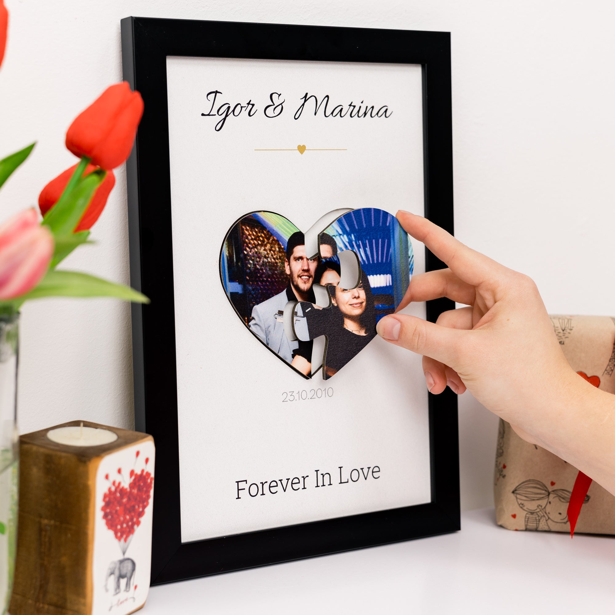 Heart-shaped photo frame with 'Igor & Marina' and 'Forever In Love' text, held by a hand.