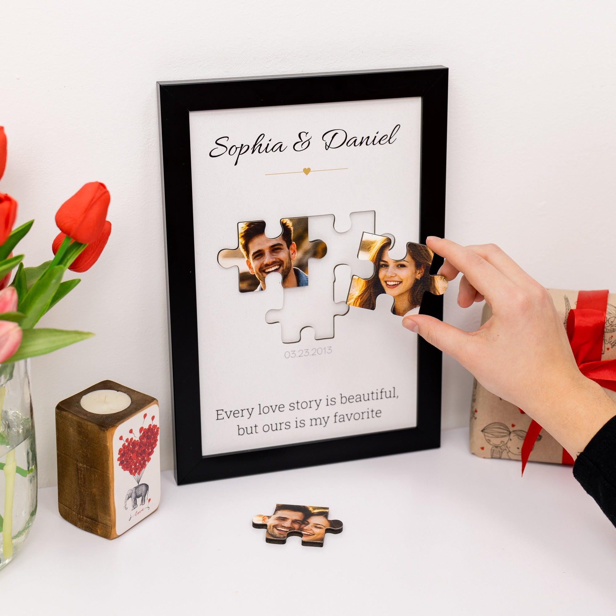 Personalized photo puzzle in a frame with a couple's names and a romantic quote, surrounded by flowers and gifts.