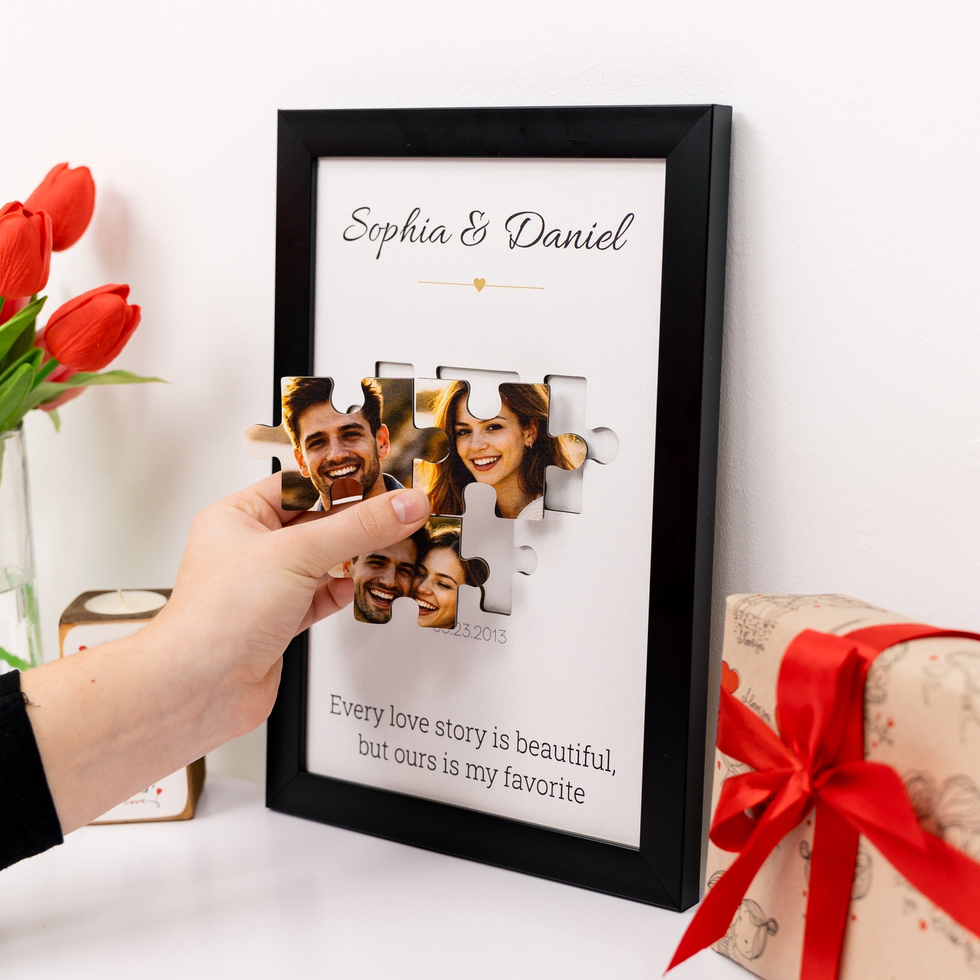 Framed photo puzzle with a couple's faces, surrounded by red tulips and a gift box.