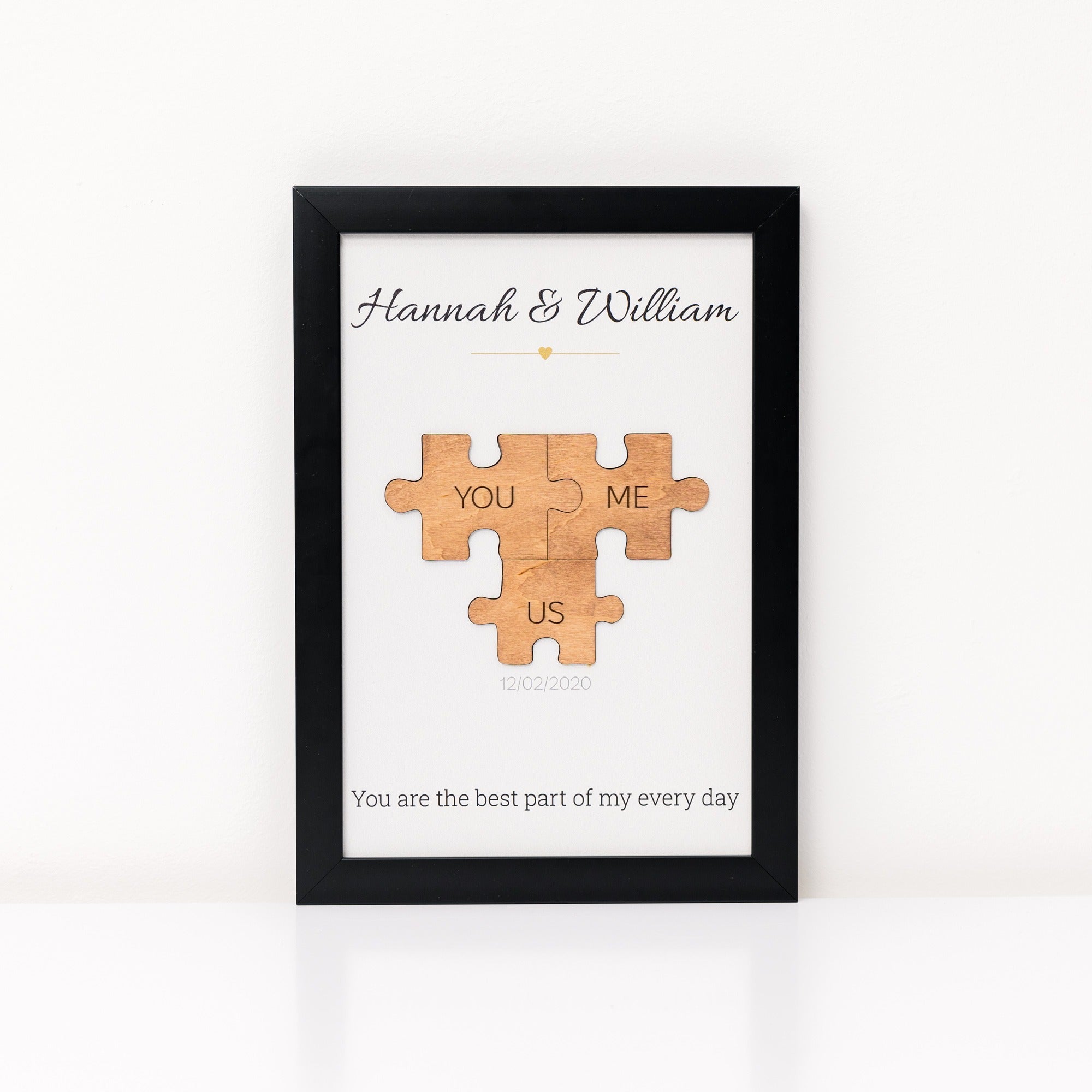 Framed artwork with wooden puzzle pieces and text on a white background