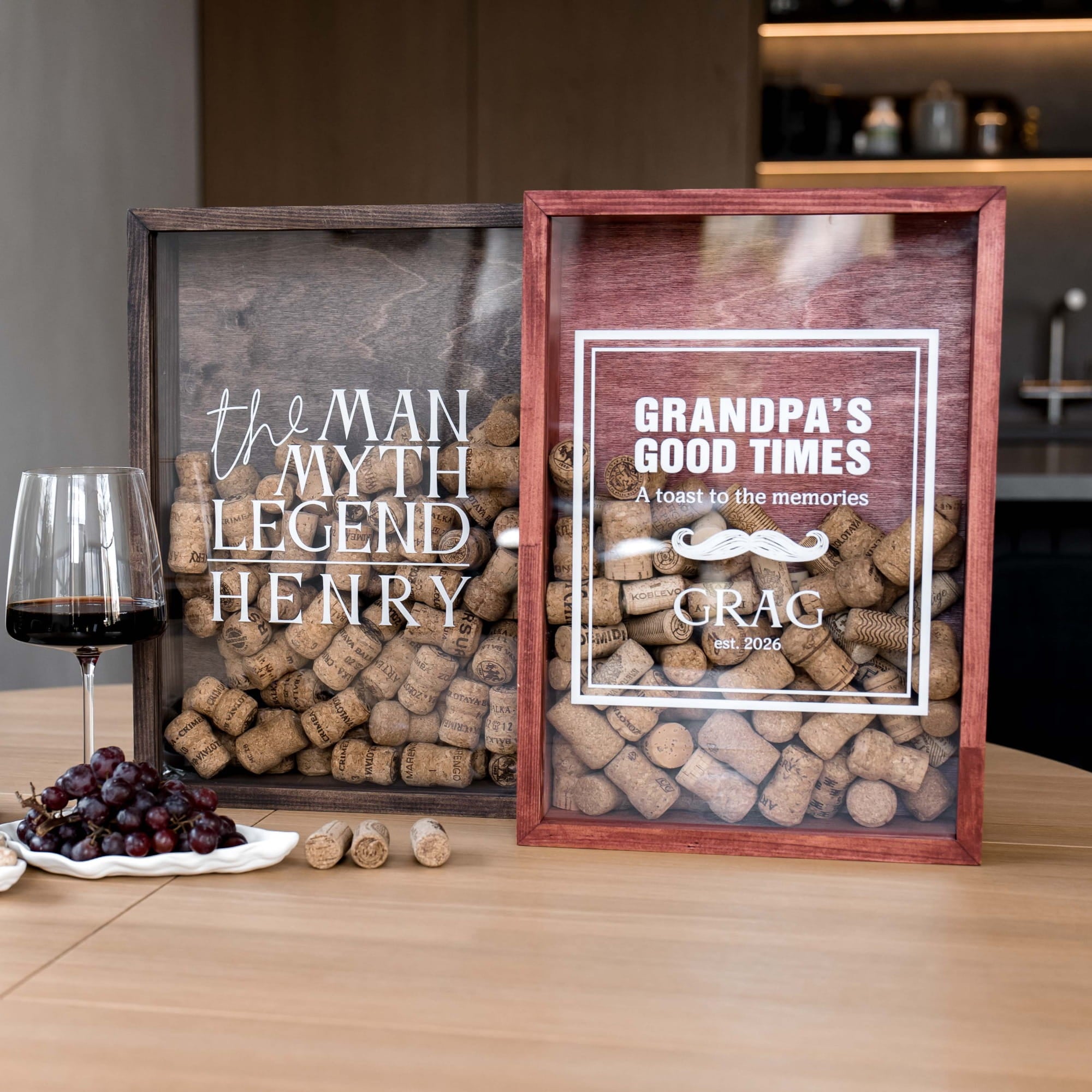 Two personalized wooden wine cork boxes on a light wood table
