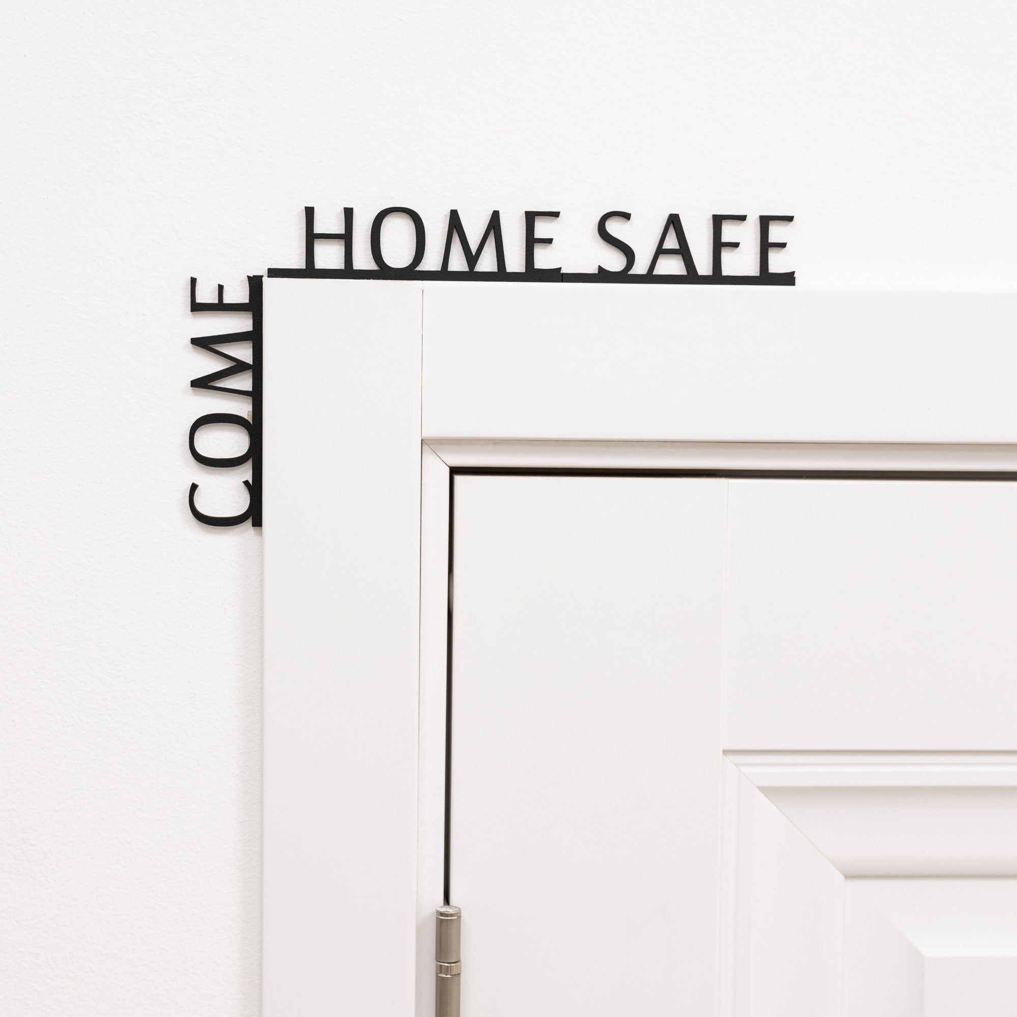 Decorative metal sign with 'COME HOME SAFE' text on a white background