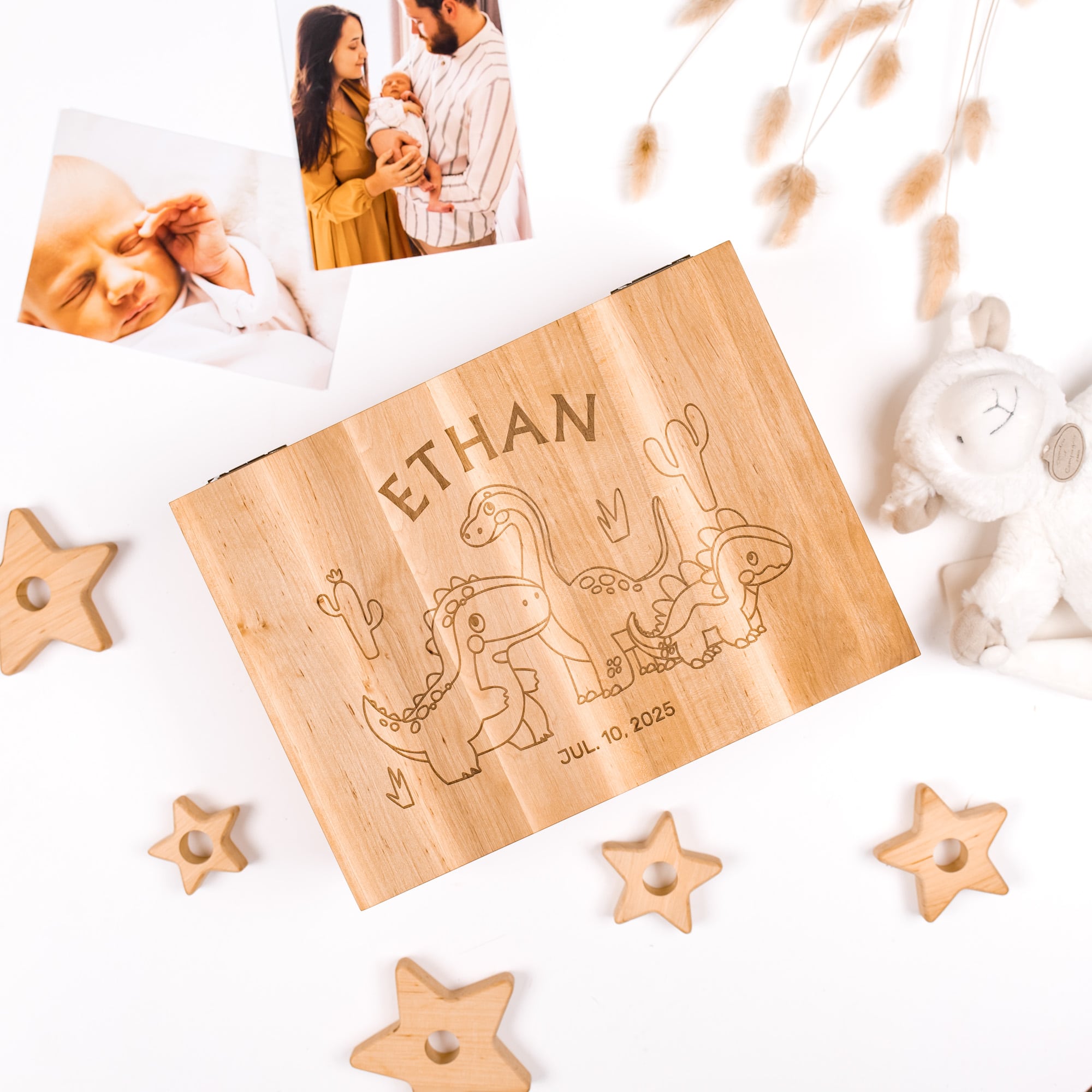 Wooden plaque with engraved name and dates, surrounded by star-shaped objects and a baby photo.