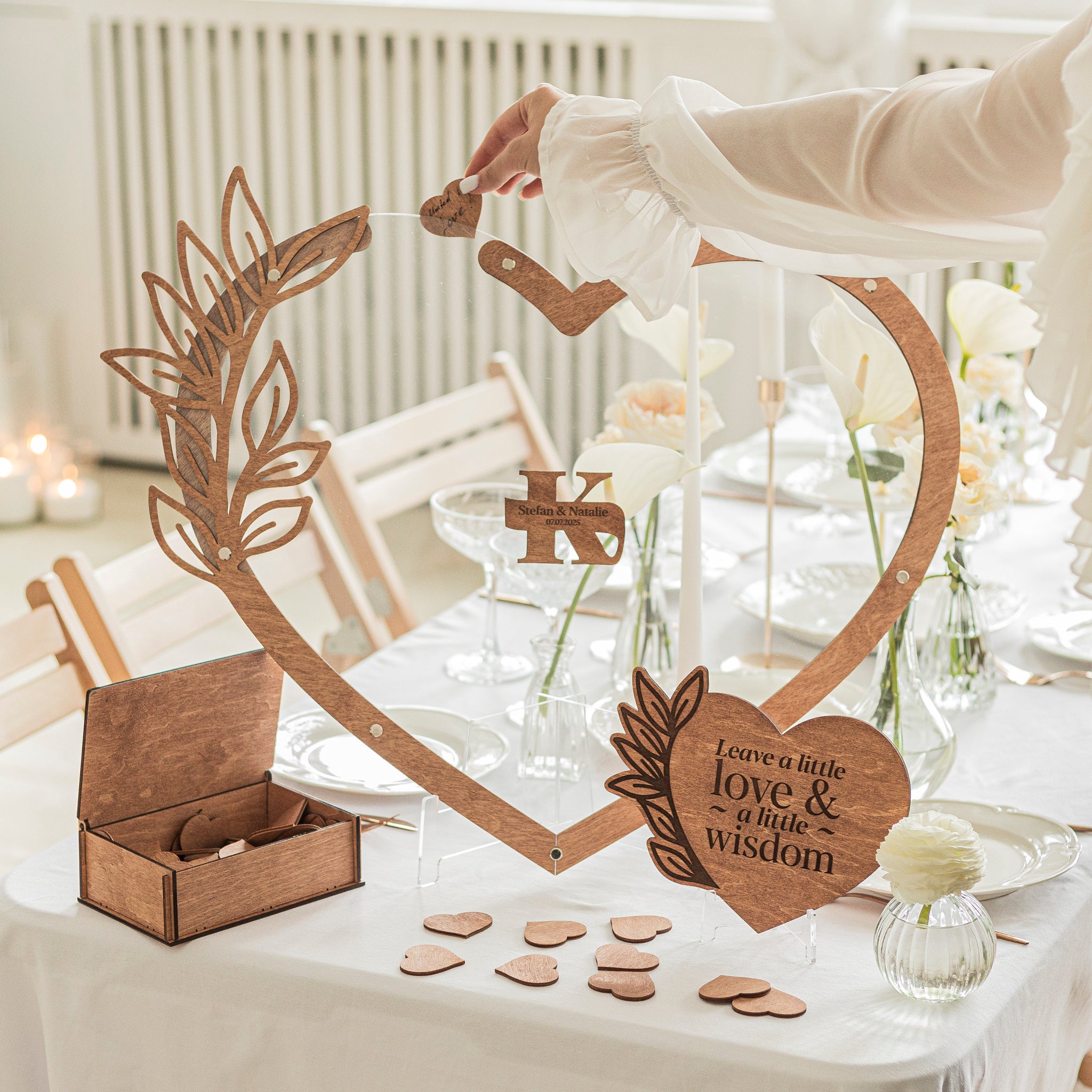 Wooden heart-shaped frame with decorative elements on a table setting.
