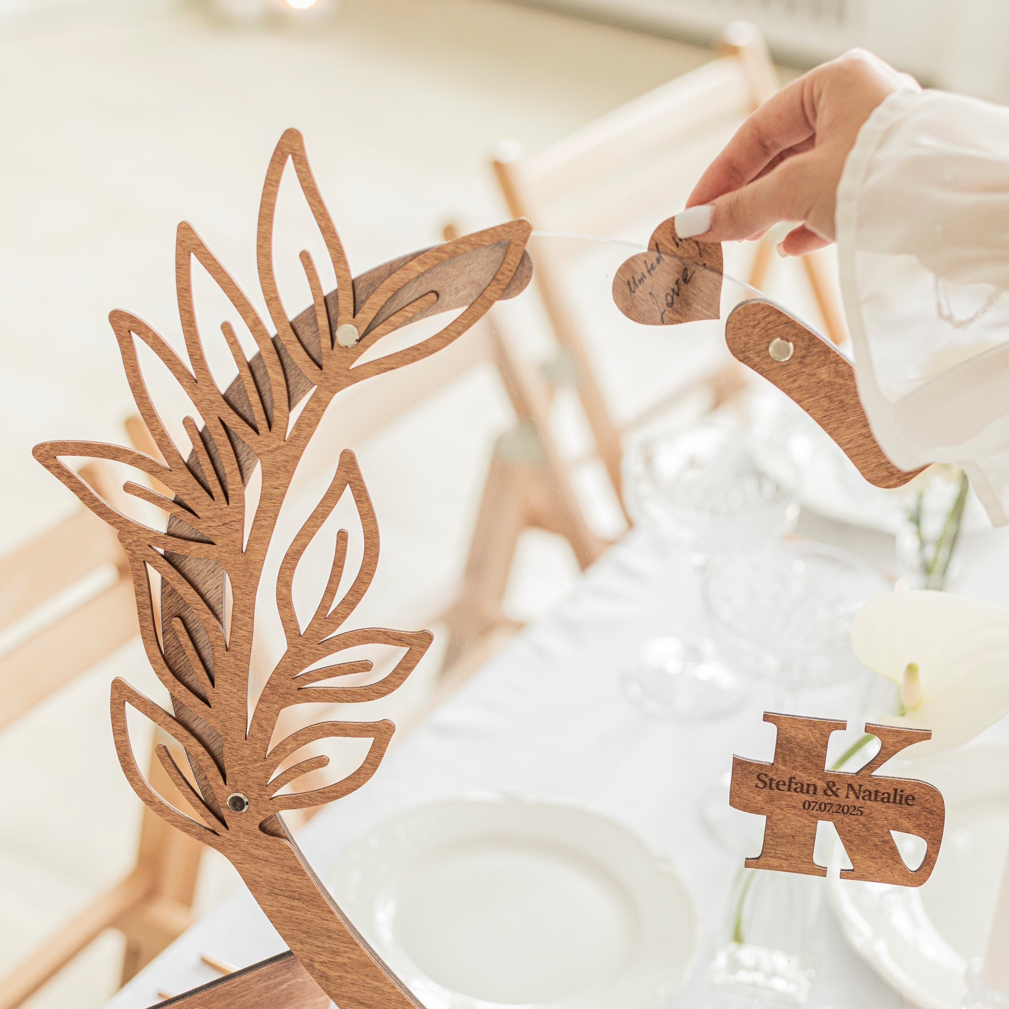 Wooden deer head and antlers with personalized heart-shaped tags on a white surface.