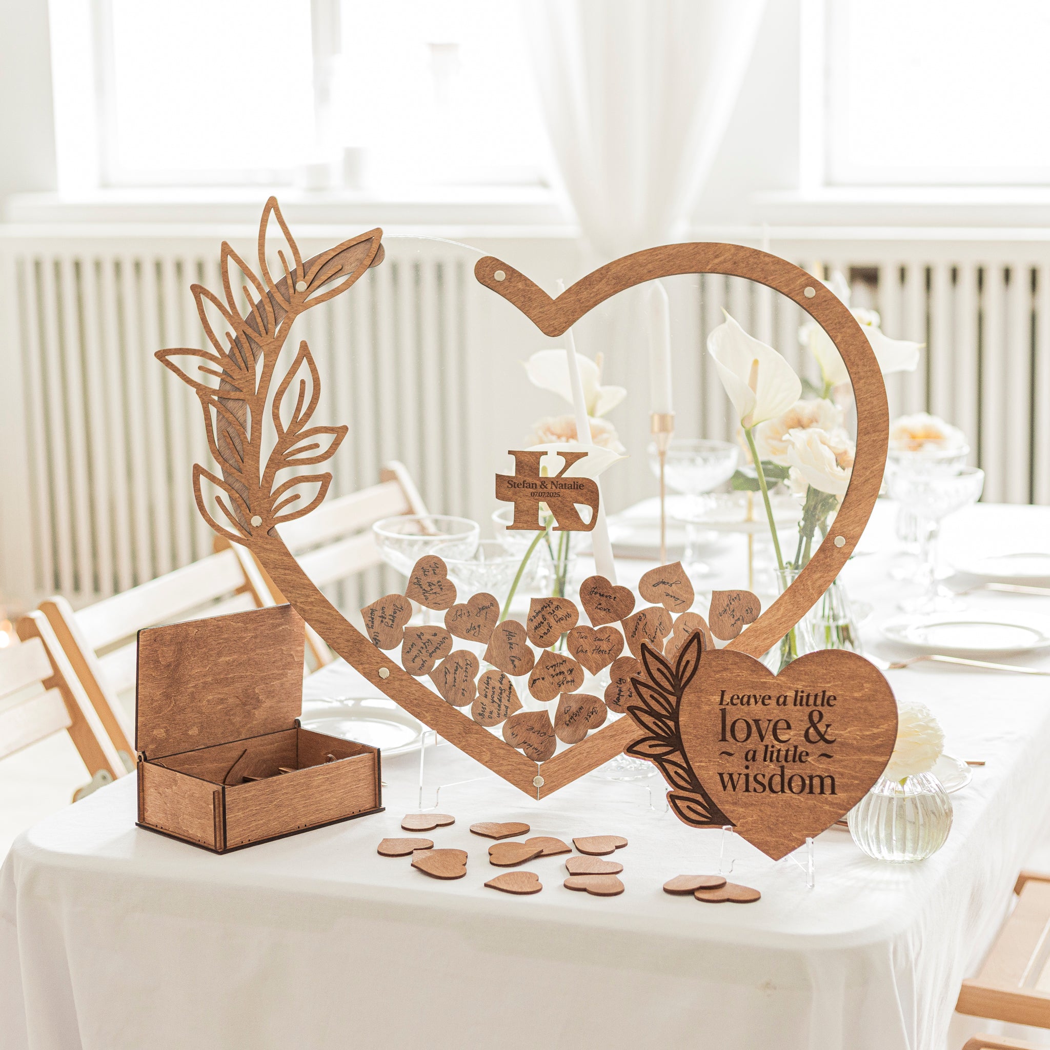 Wooden heart-shaped decoration with cut-out designs on a table with white tablecloth.