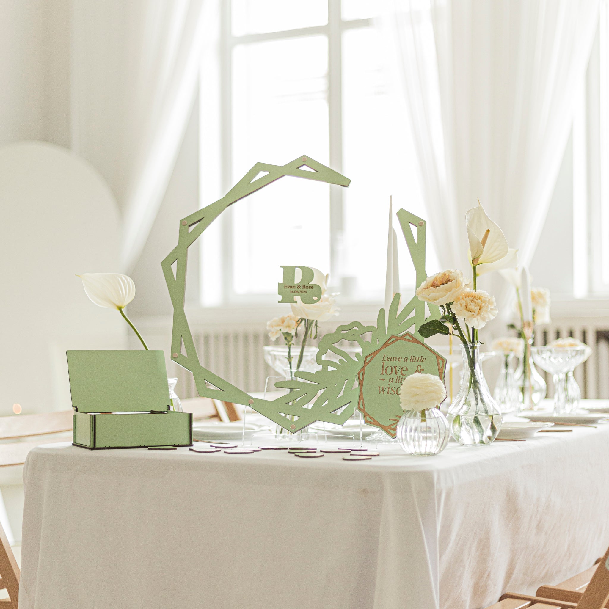 Decorative table centerpieces with green frames on a white tablecloth.
