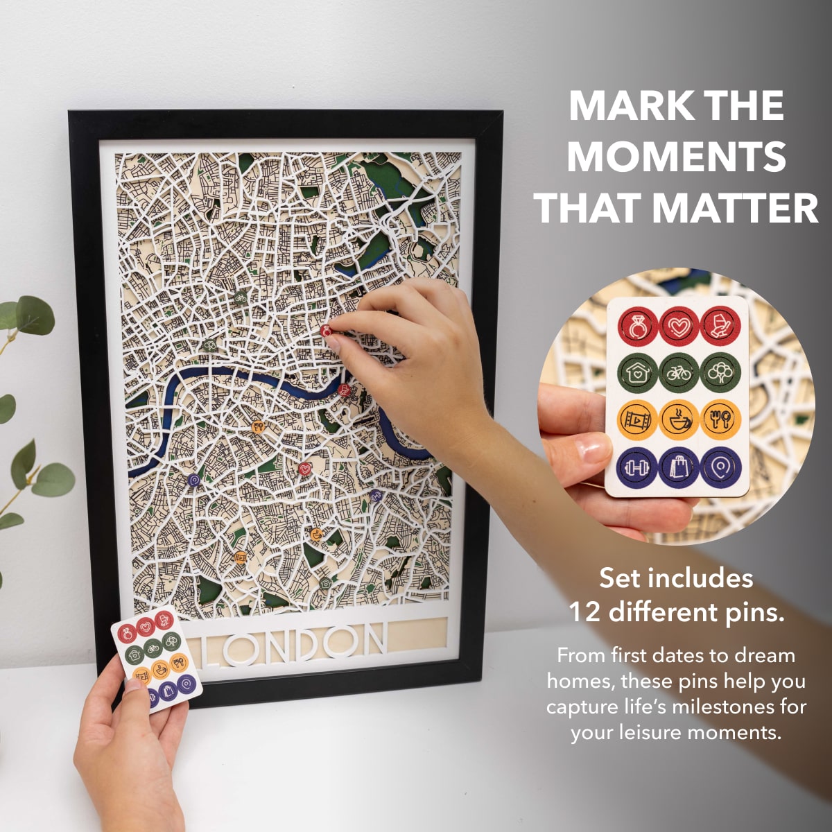 Framed map of London with decorative pins and a set of pins on a white background.