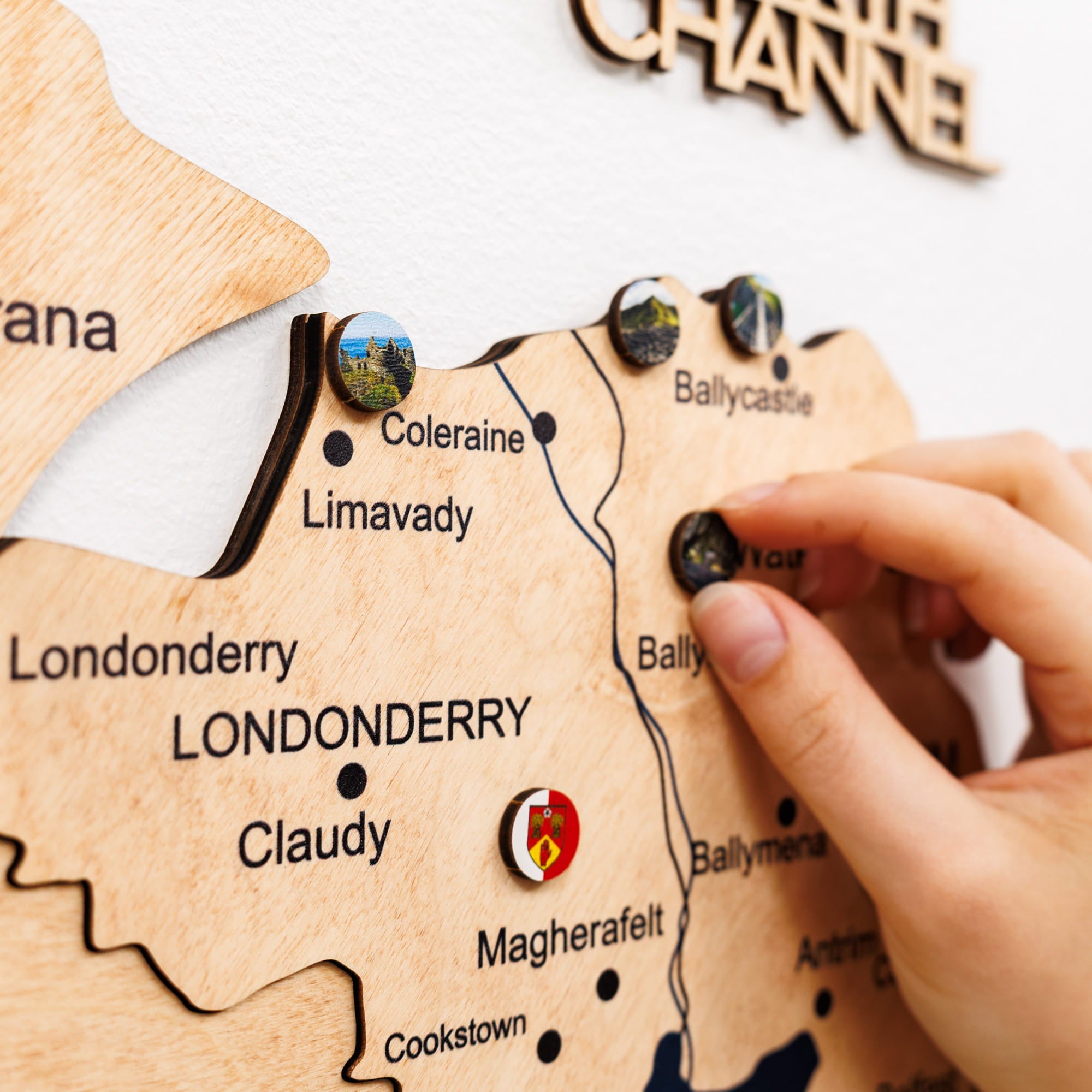 Wooden map of Northern Ireland with pins marking locations, including Londonderry.