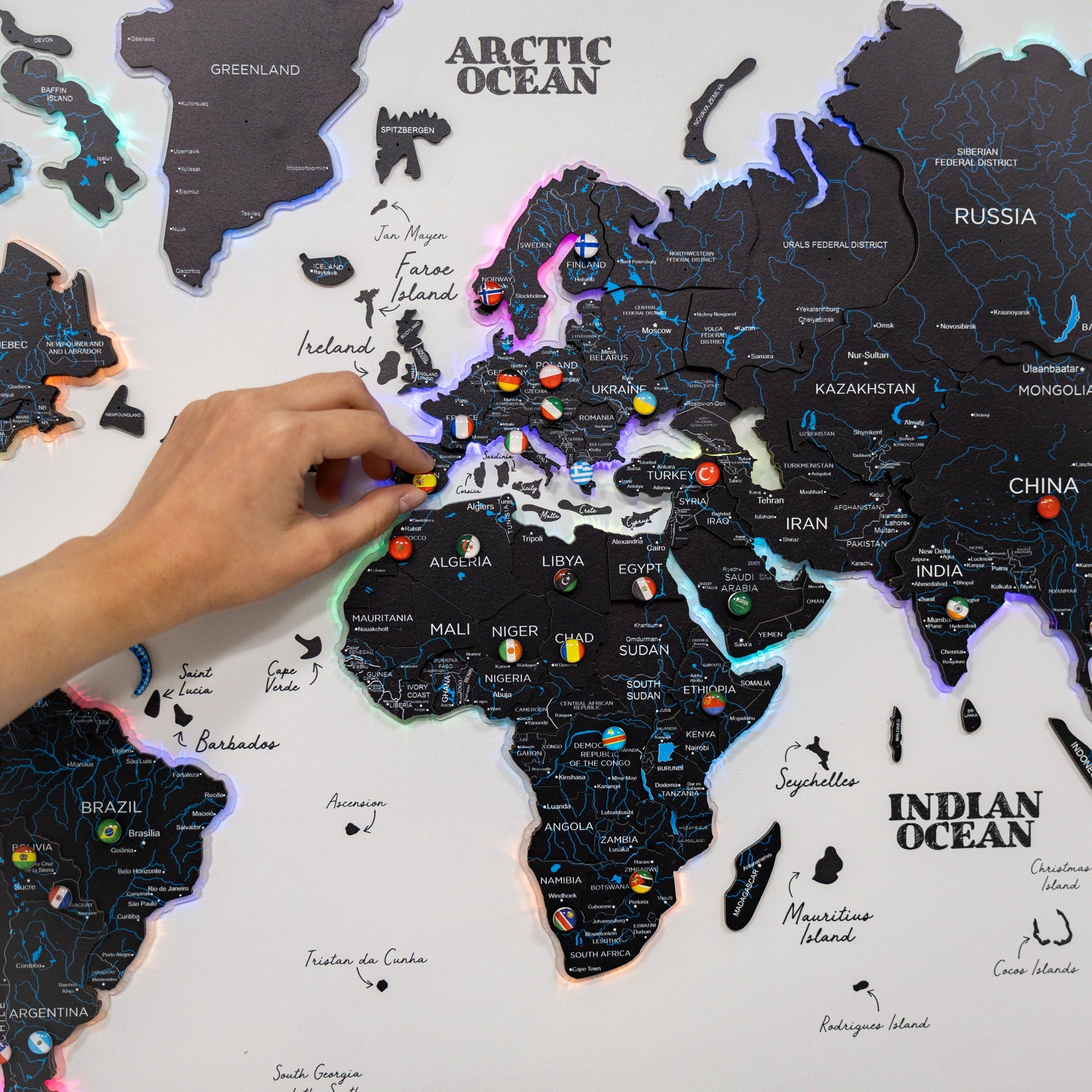 World map with illuminated features, hand pointing at a location on Africa