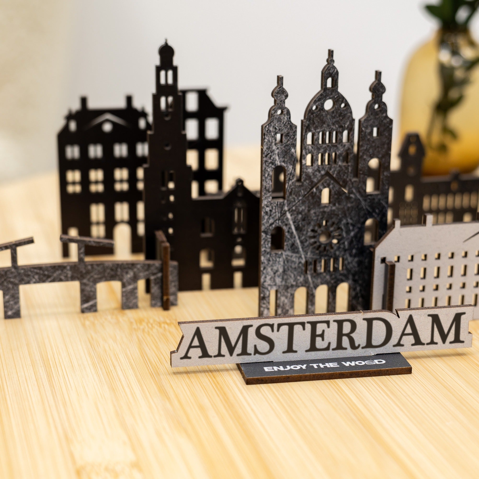 Model of Amsterdam with buildings and 'AMSTERDAM' sign on a wooden surface
