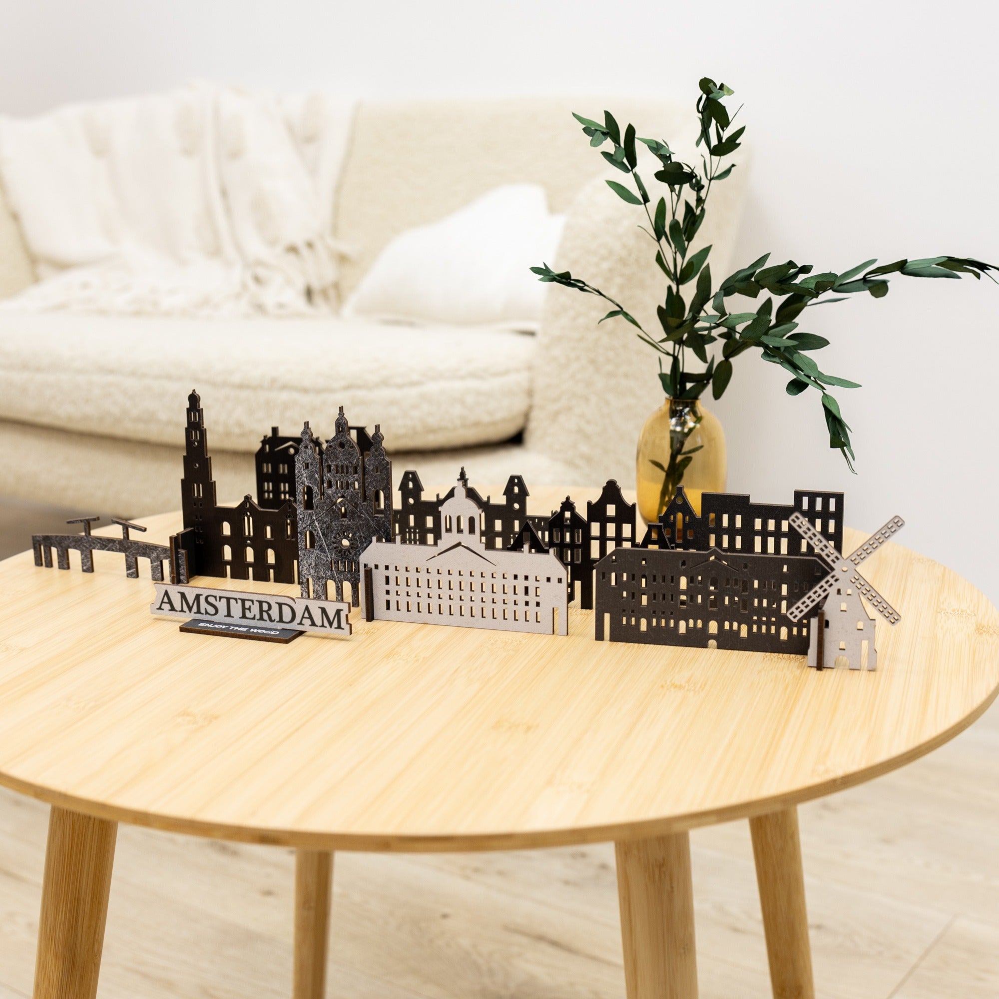 Model of Amsterdam skyline on a wooden table with a plant and white sofa in the background