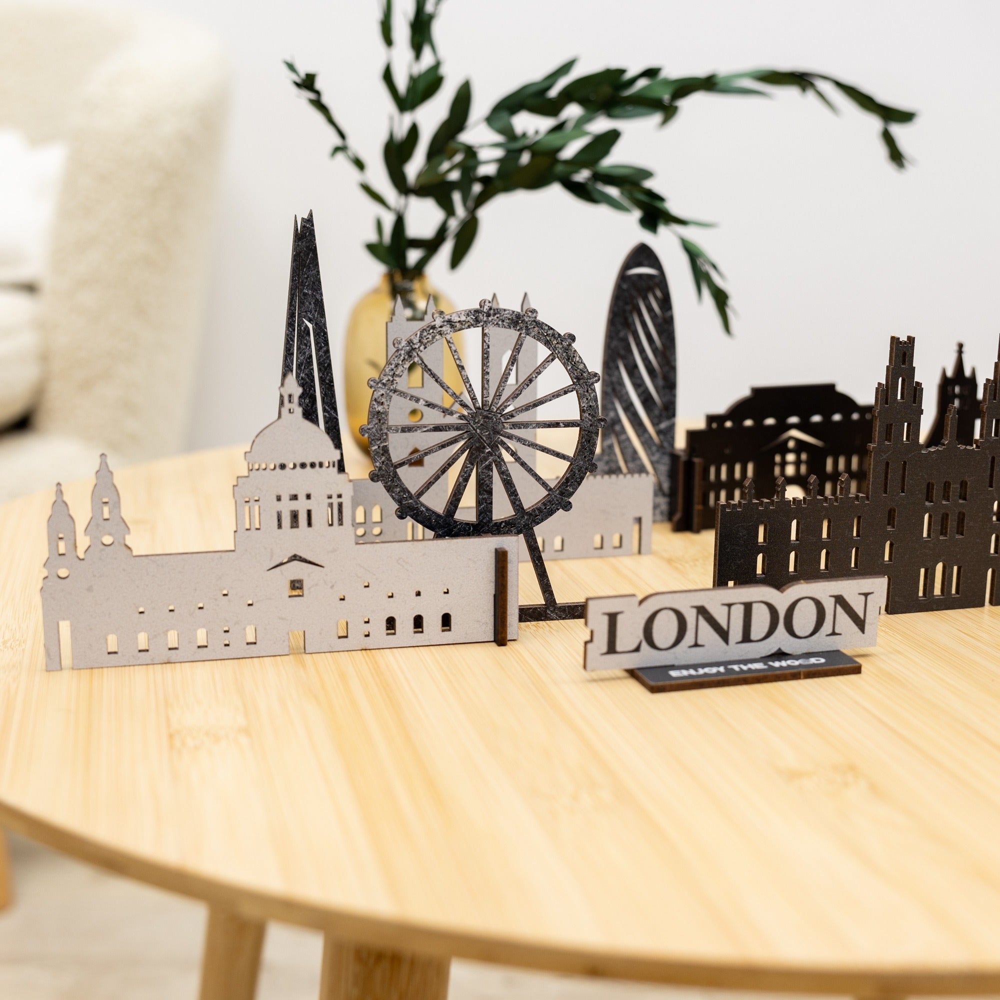 Model of London skyline on a wooden table with a plant in the background