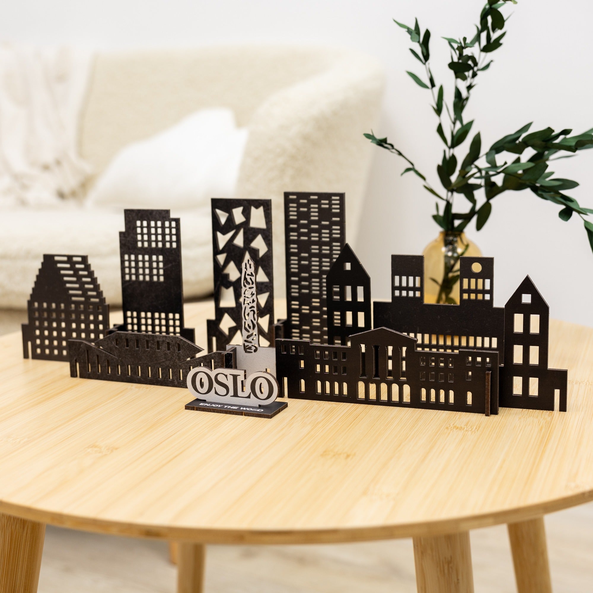 Model of a city skyline with 'OSLO' on a wooden table