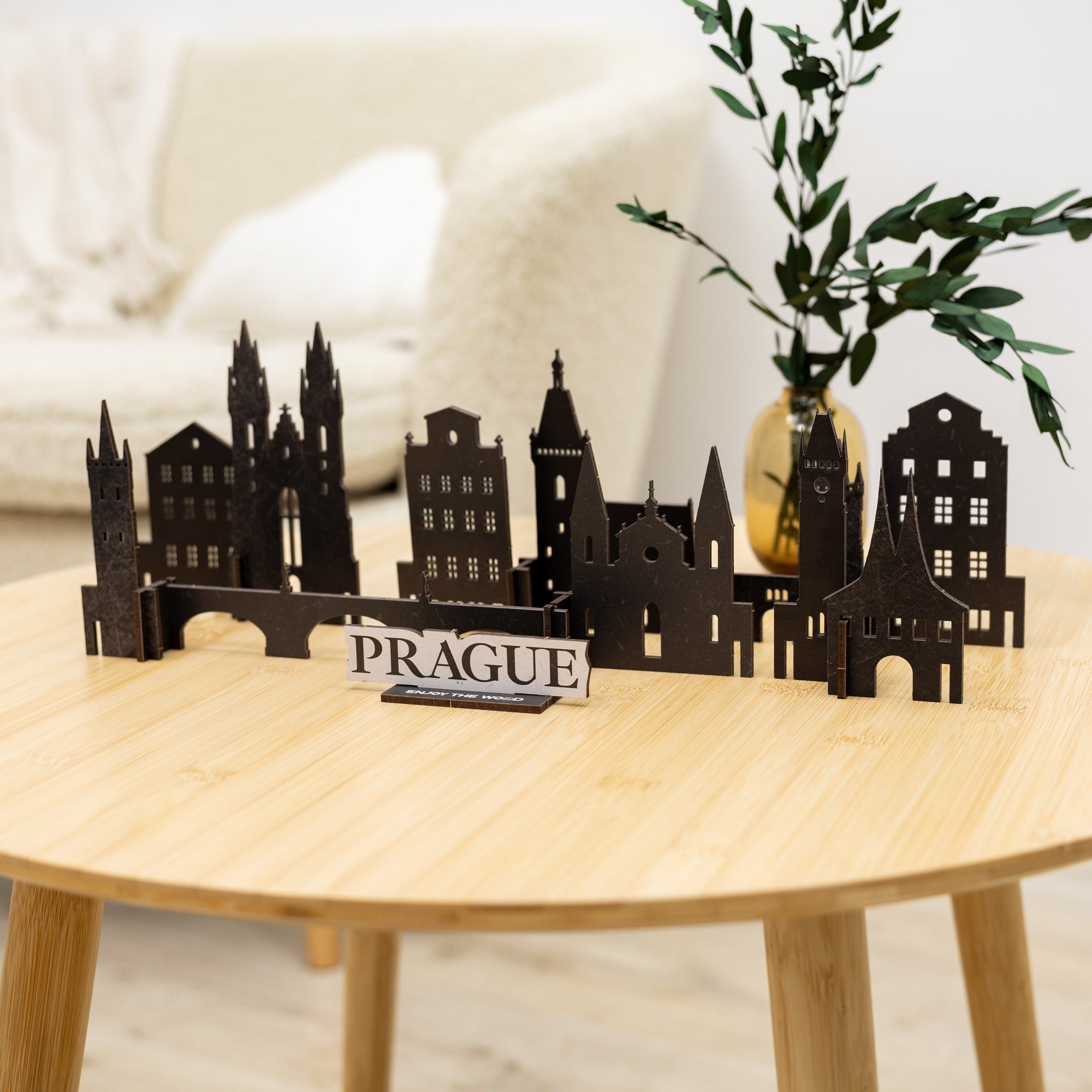 Model of Prague skyline on a wooden table with a plant in the background