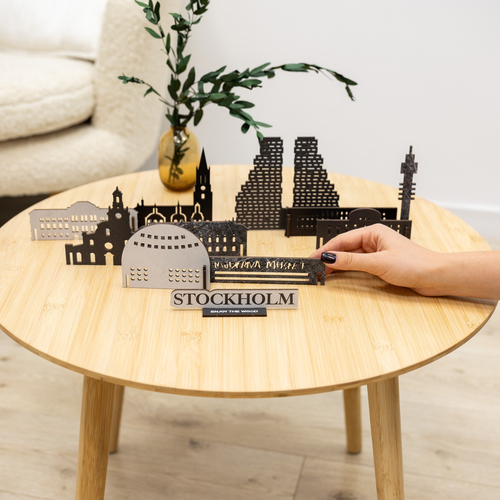 Model of Stockholm skyline on a wooden table with a hand holding it