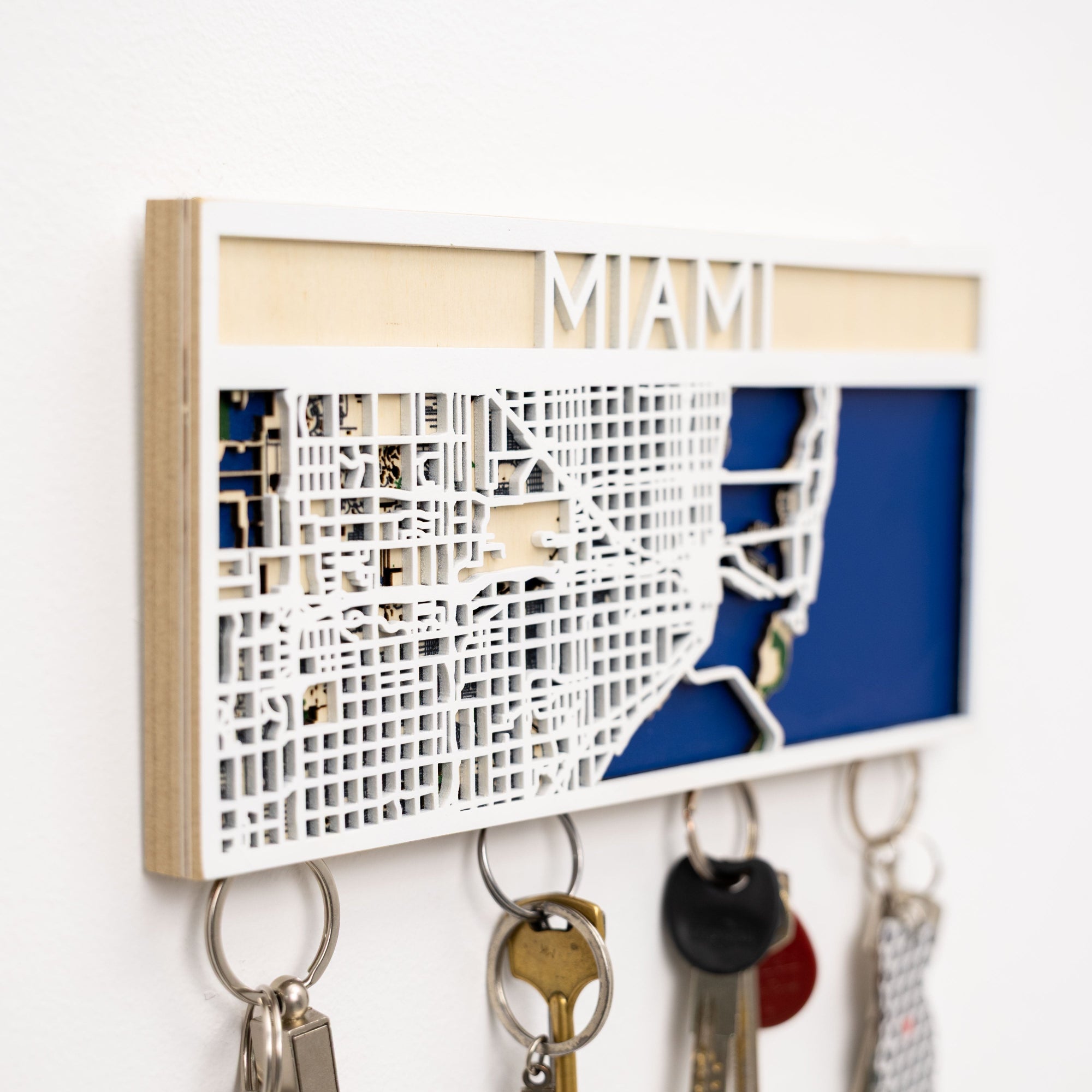 Key holder with a map design of Miami, holding various keys.