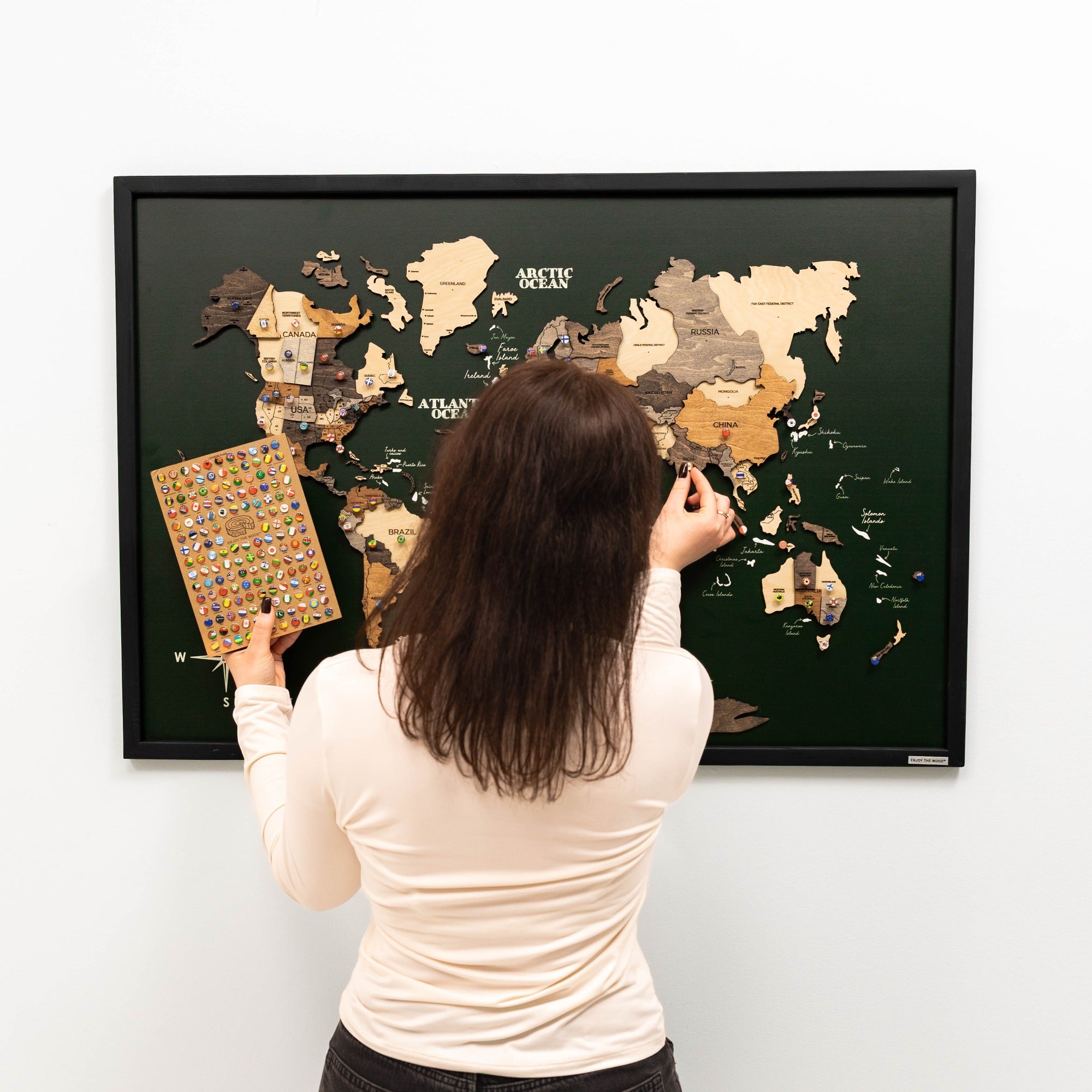Woman interacting with a world map on a wall