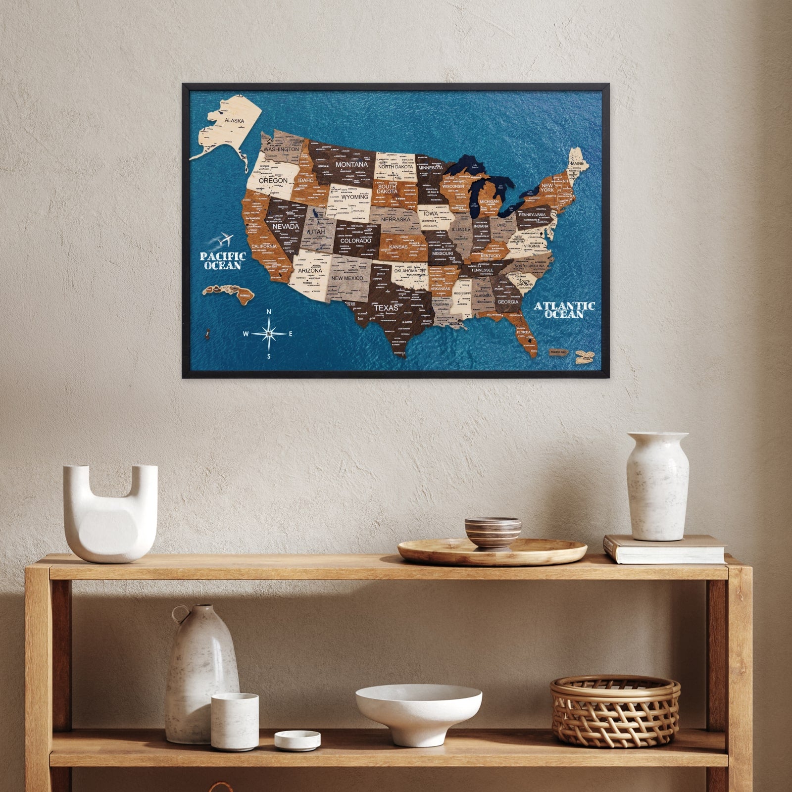 Framed map of the United States on a wall above a wooden shelf with decorative items.