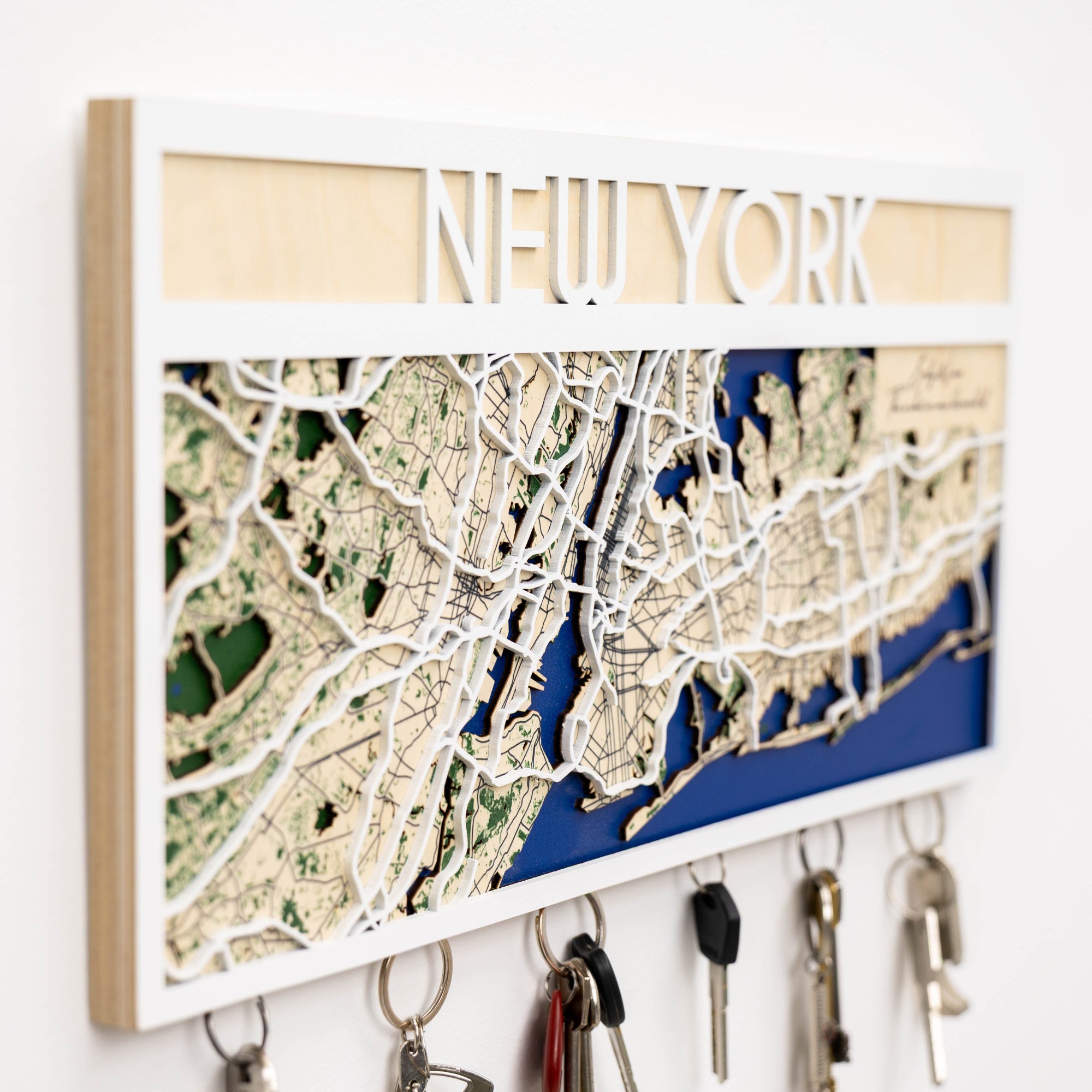 Wooden key holder with New York map design on a white wall