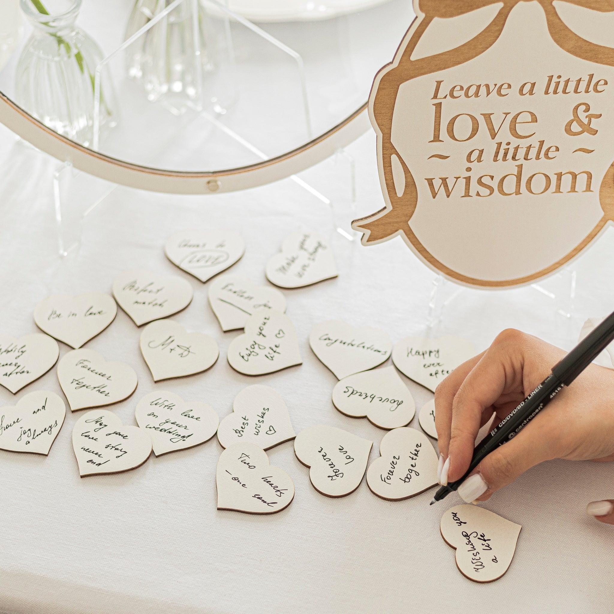 Heart-shaped wooden tokens with writing on a table, accompanied by a decorative sign.