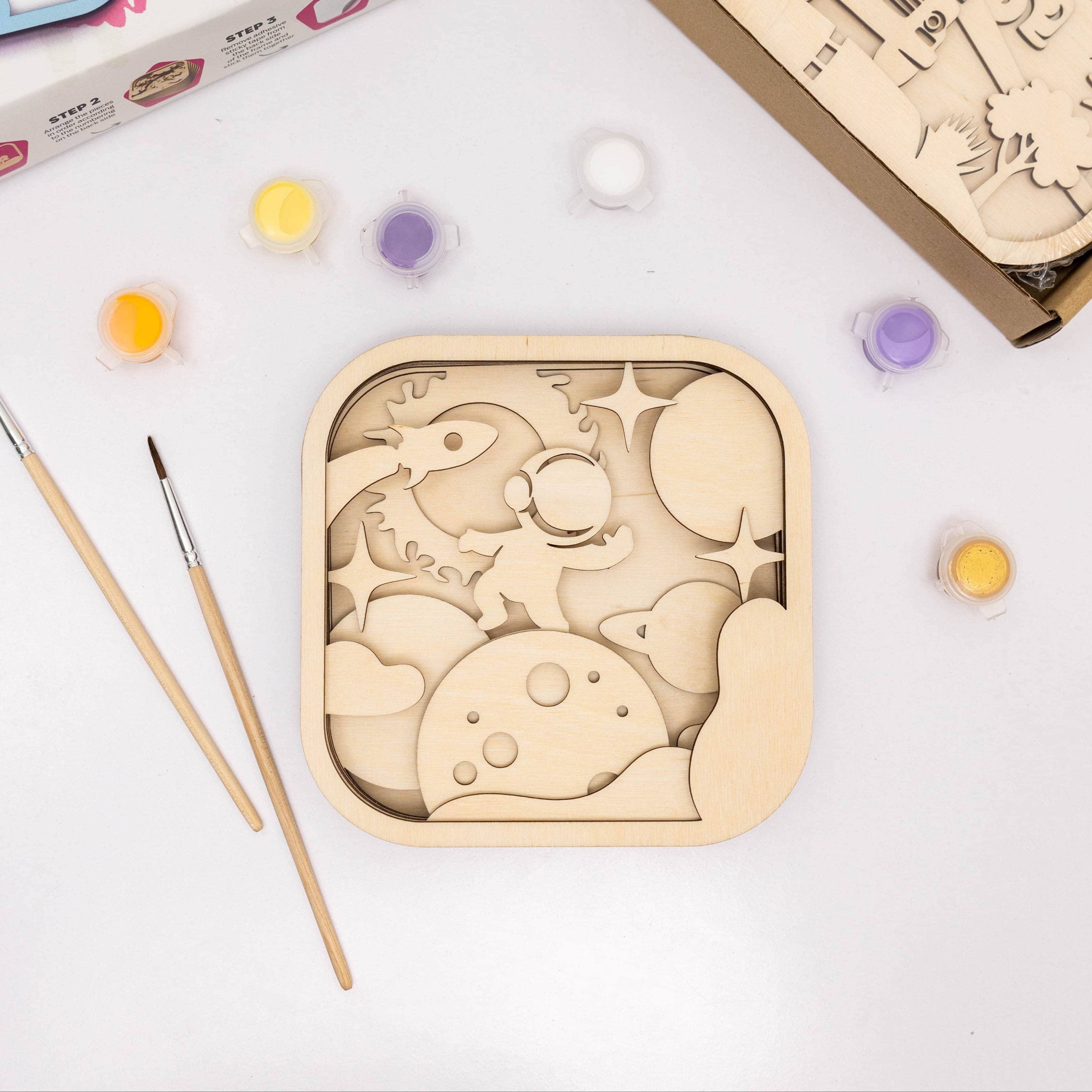 Wooden puzzle with paint and brushes on a white background