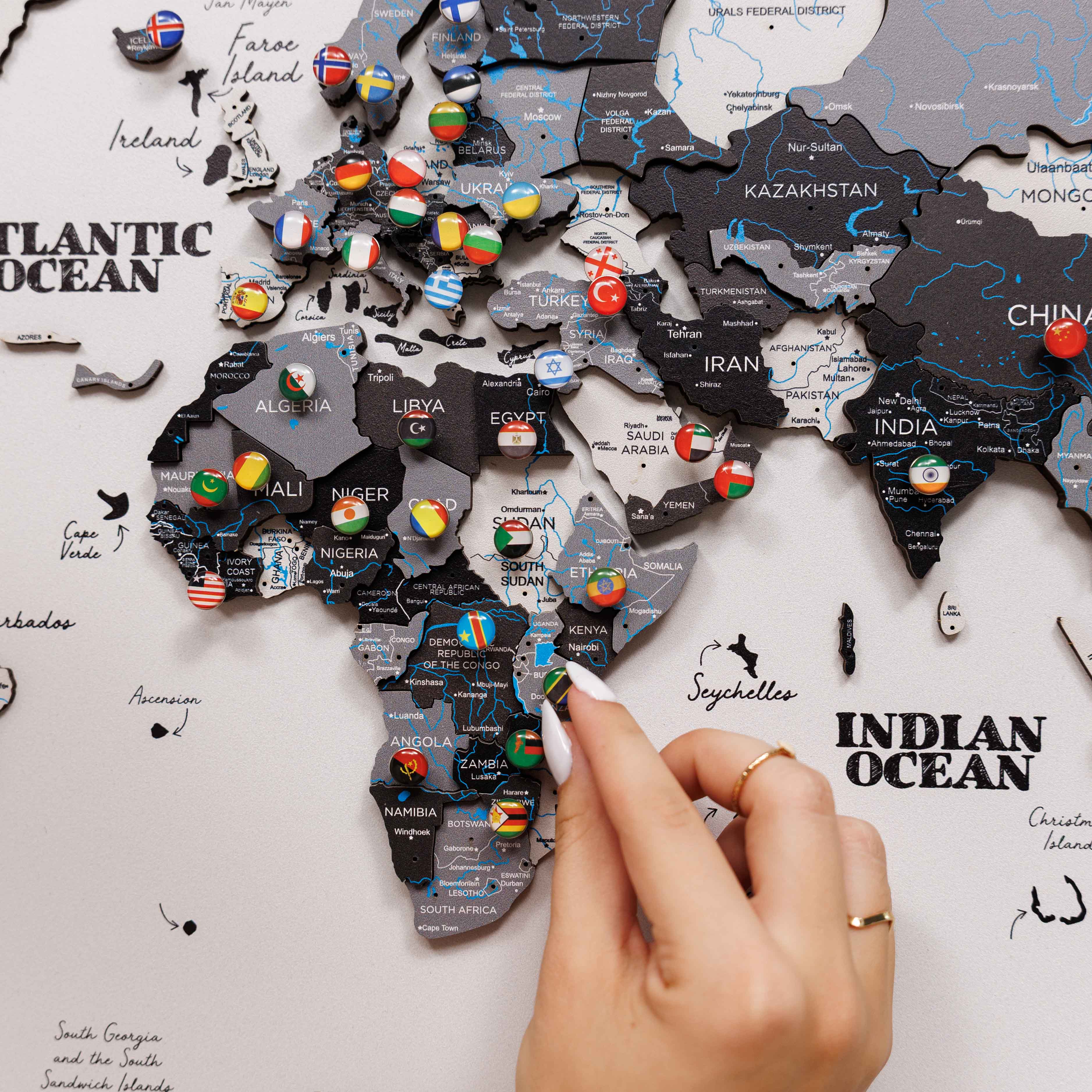 World map with country flags pinned on a white surface
