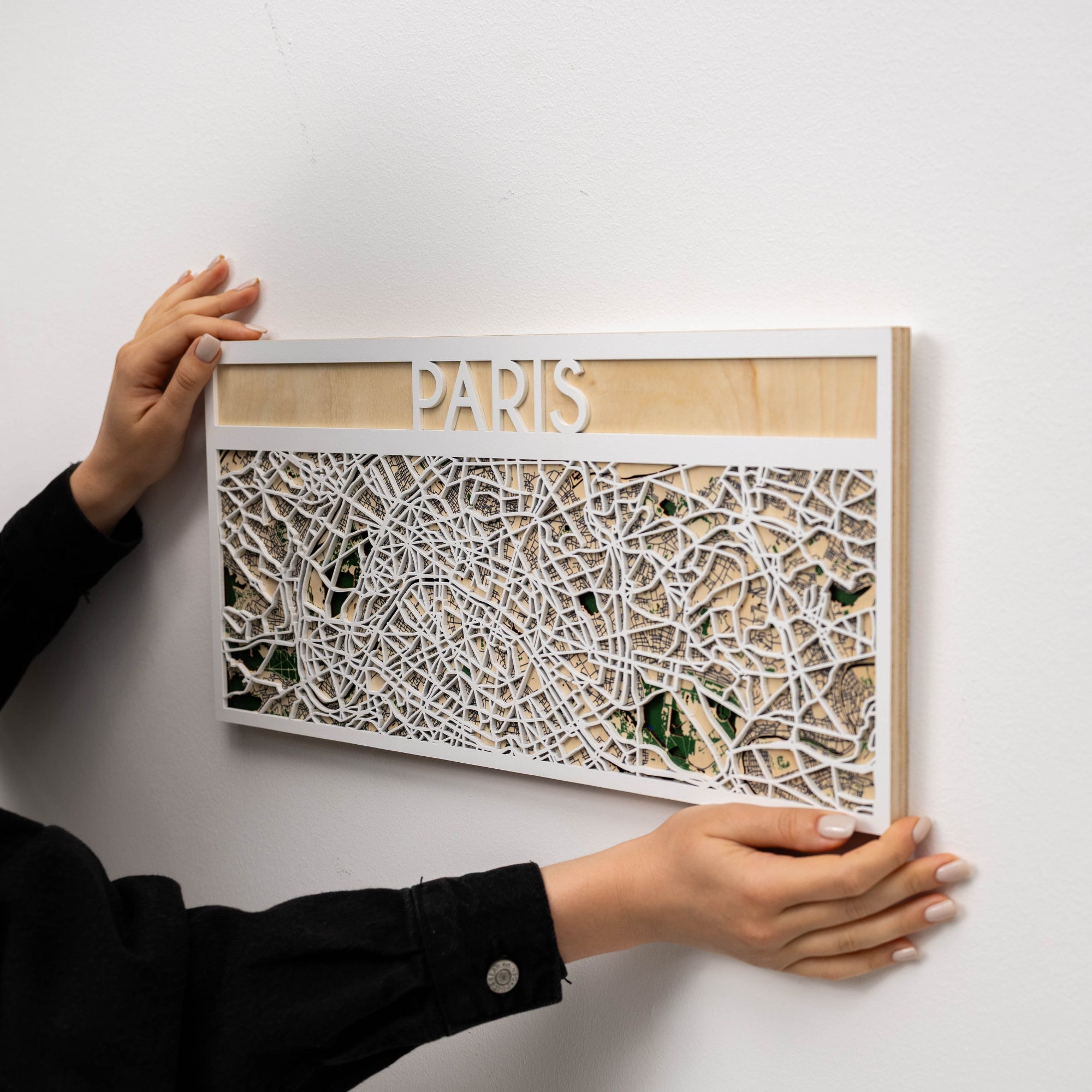 Person holding a framed map of Paris on a white background