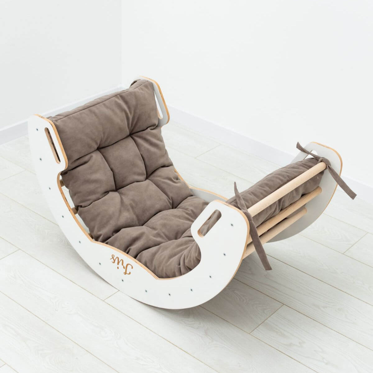 Rocker chair with brown cushion on a white floor
