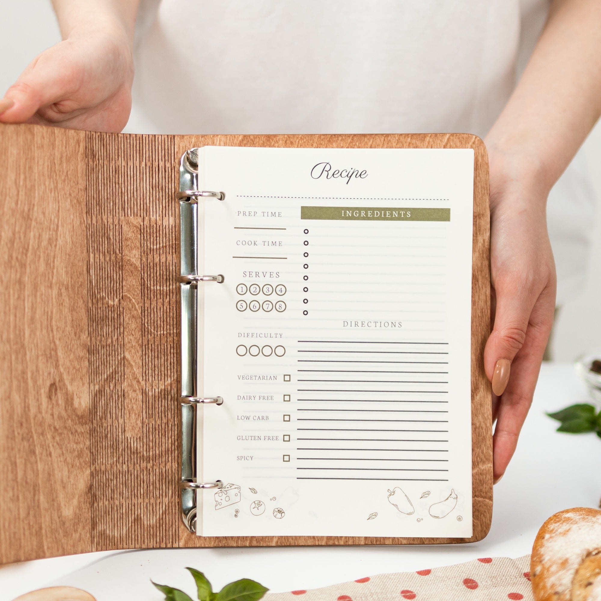Wooden recipe binder with a recipe sheet on a white surface