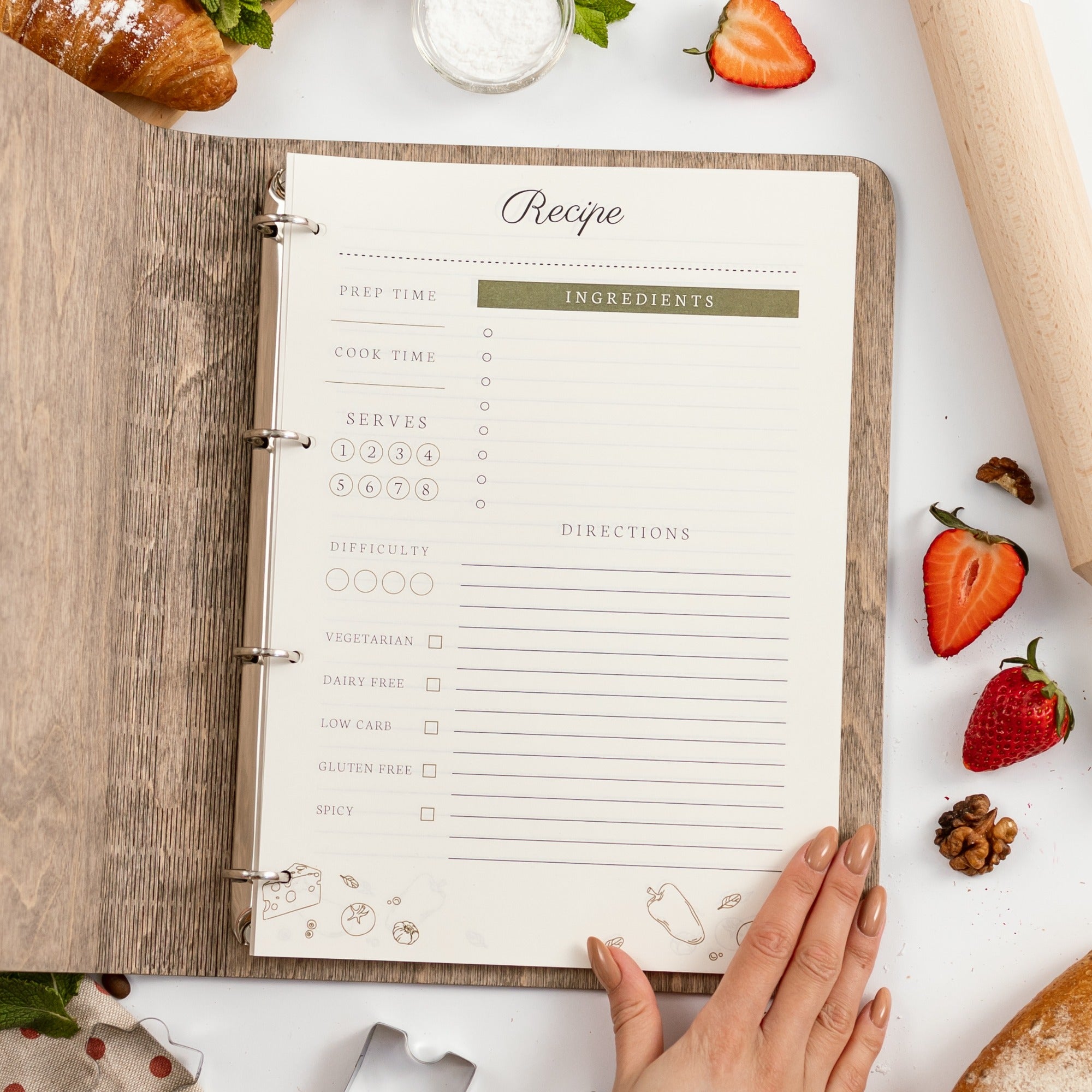 Recipe book open on a table with ingredients and a rolling pin.