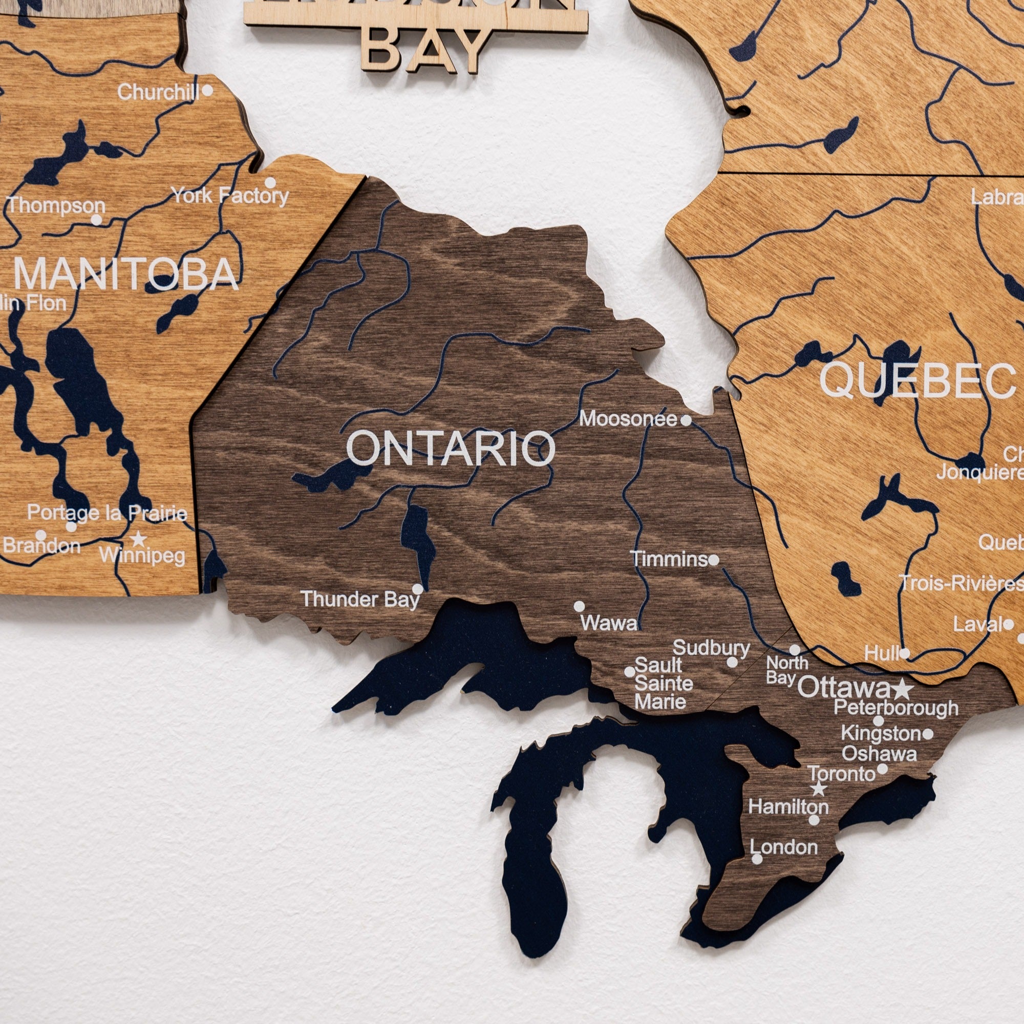 Wooden map of Canada with provinces cut out, focusing on Ontario.