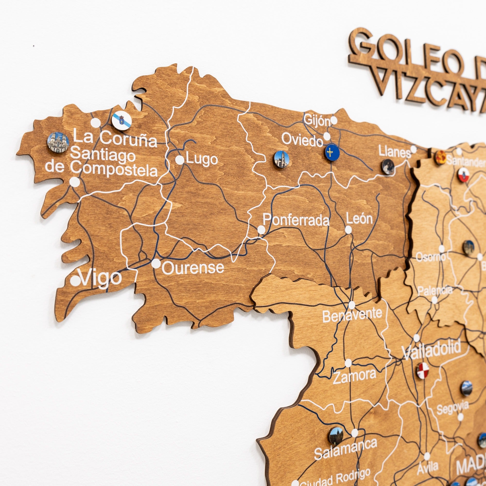 Wooden map of Spain with labeled cities on a white background