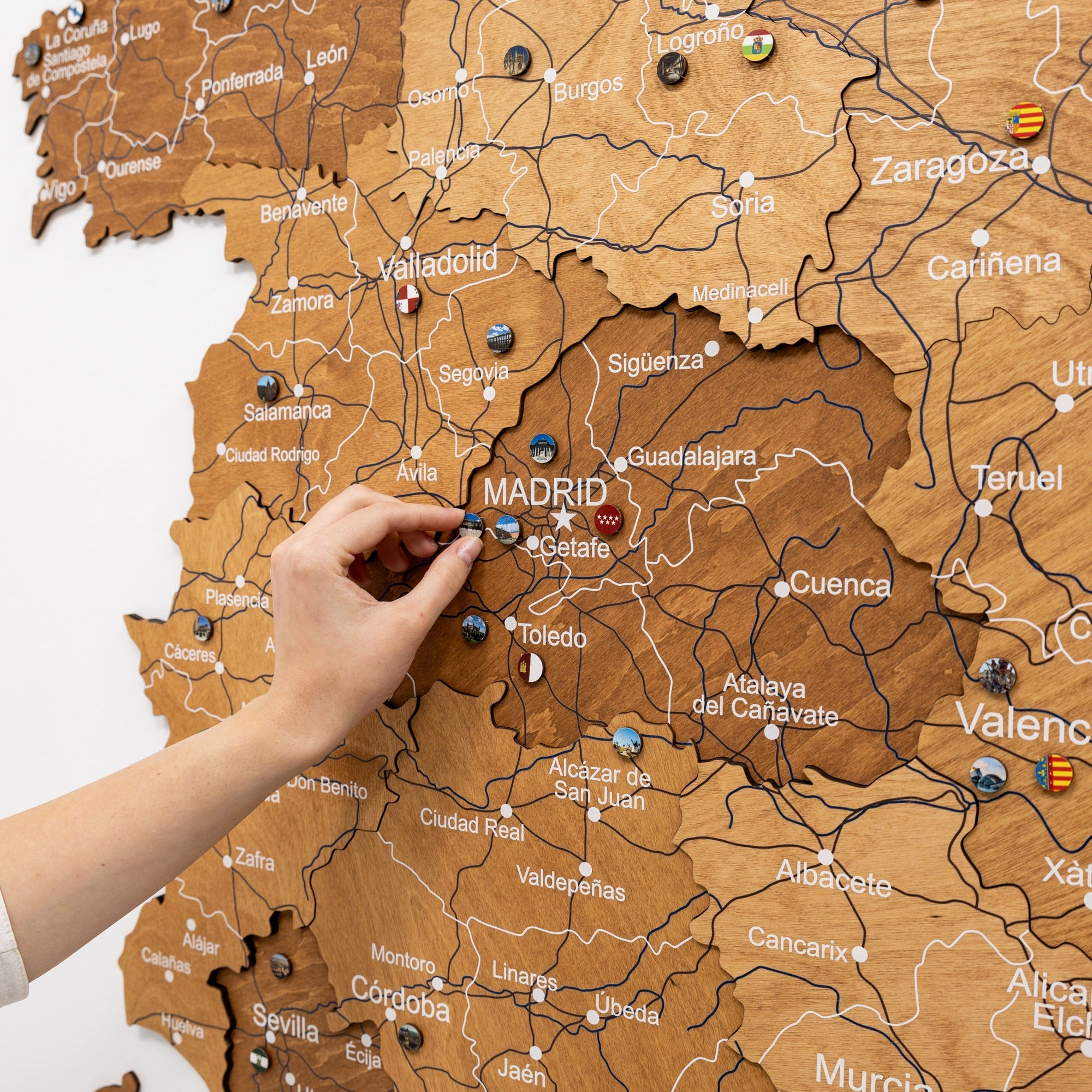 Map of Spain with a hand placing a pin on Madrid