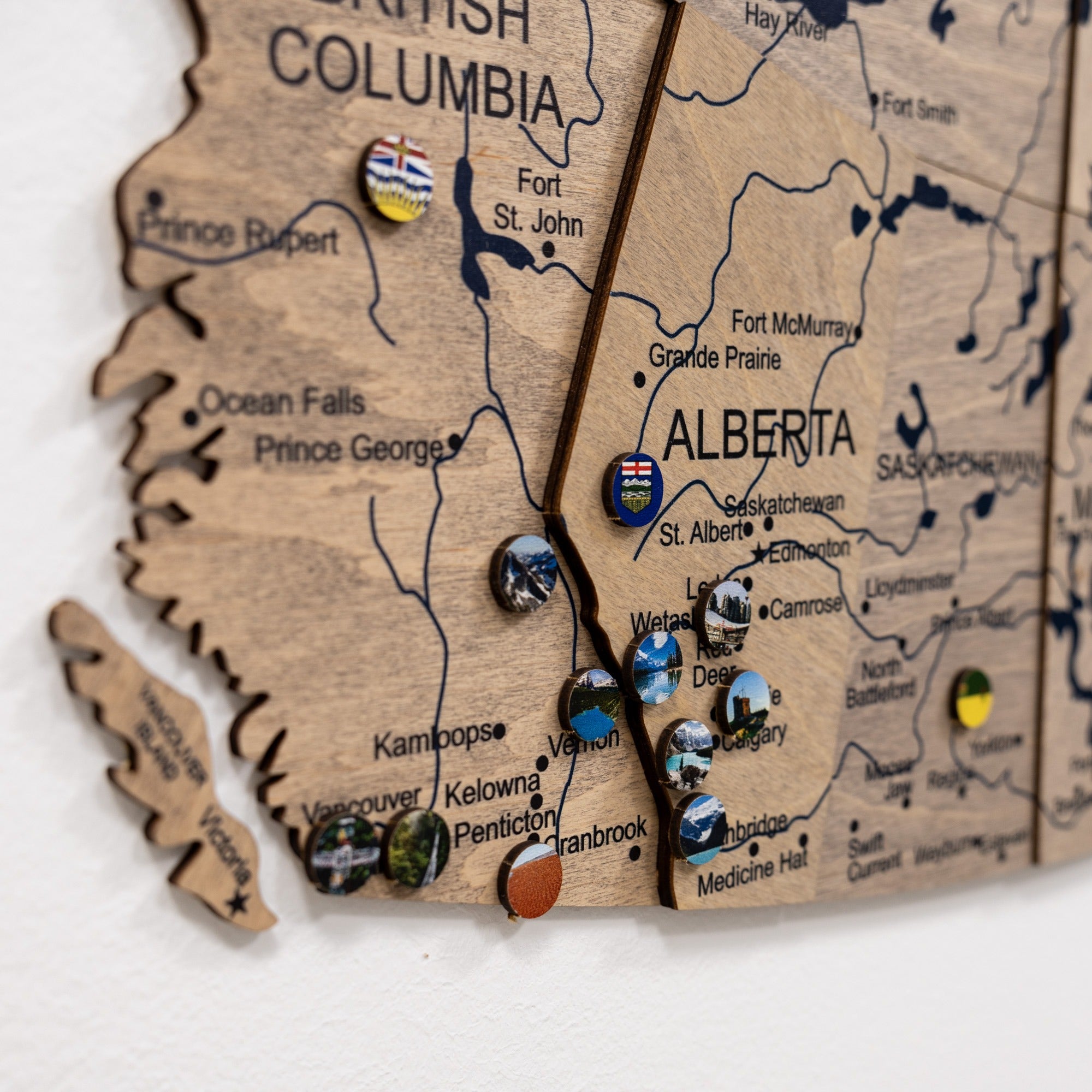 Wooden map of British Columbia and Alberta with various pins marking locations