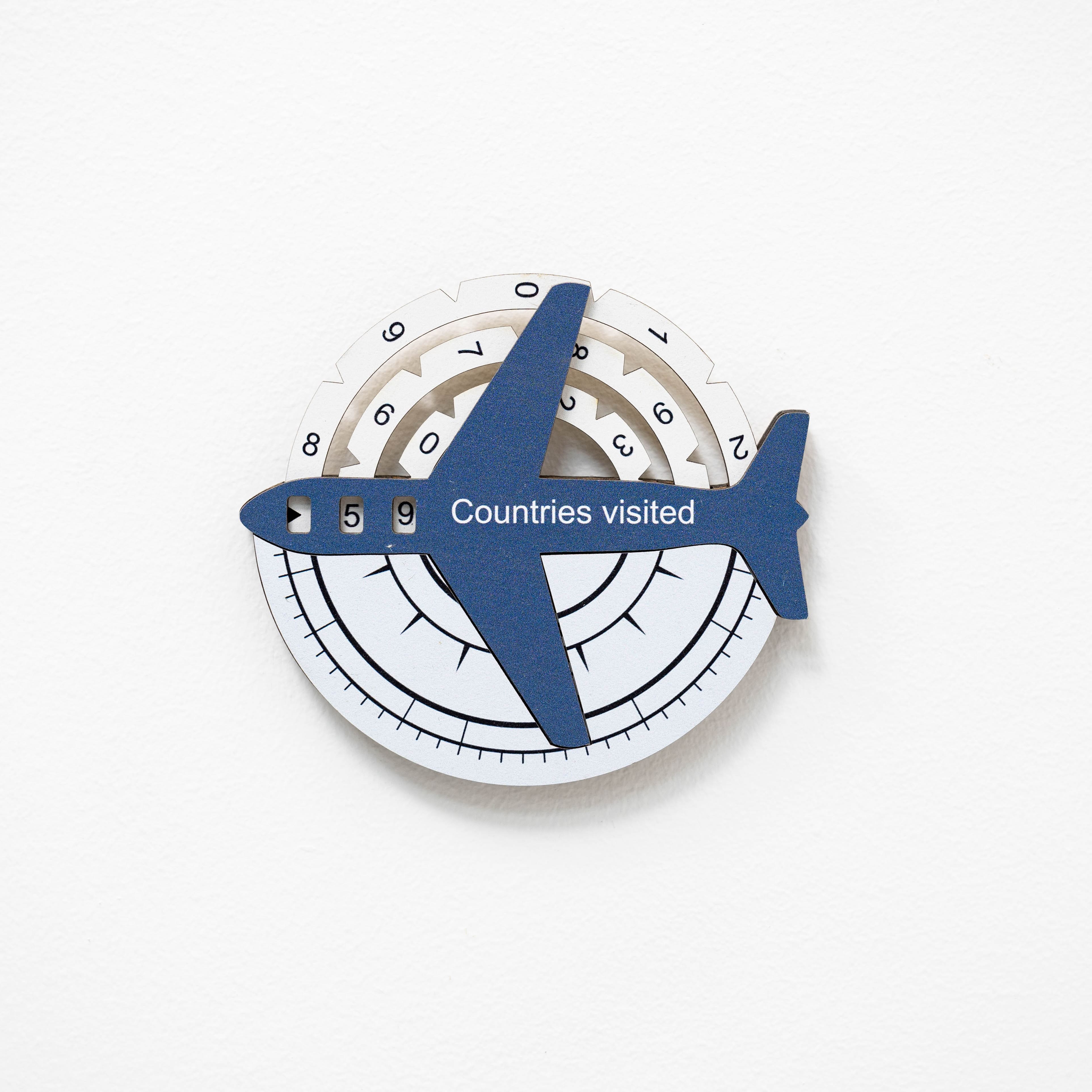 Circular device with airplane design and 'Countries visited' text on a white background