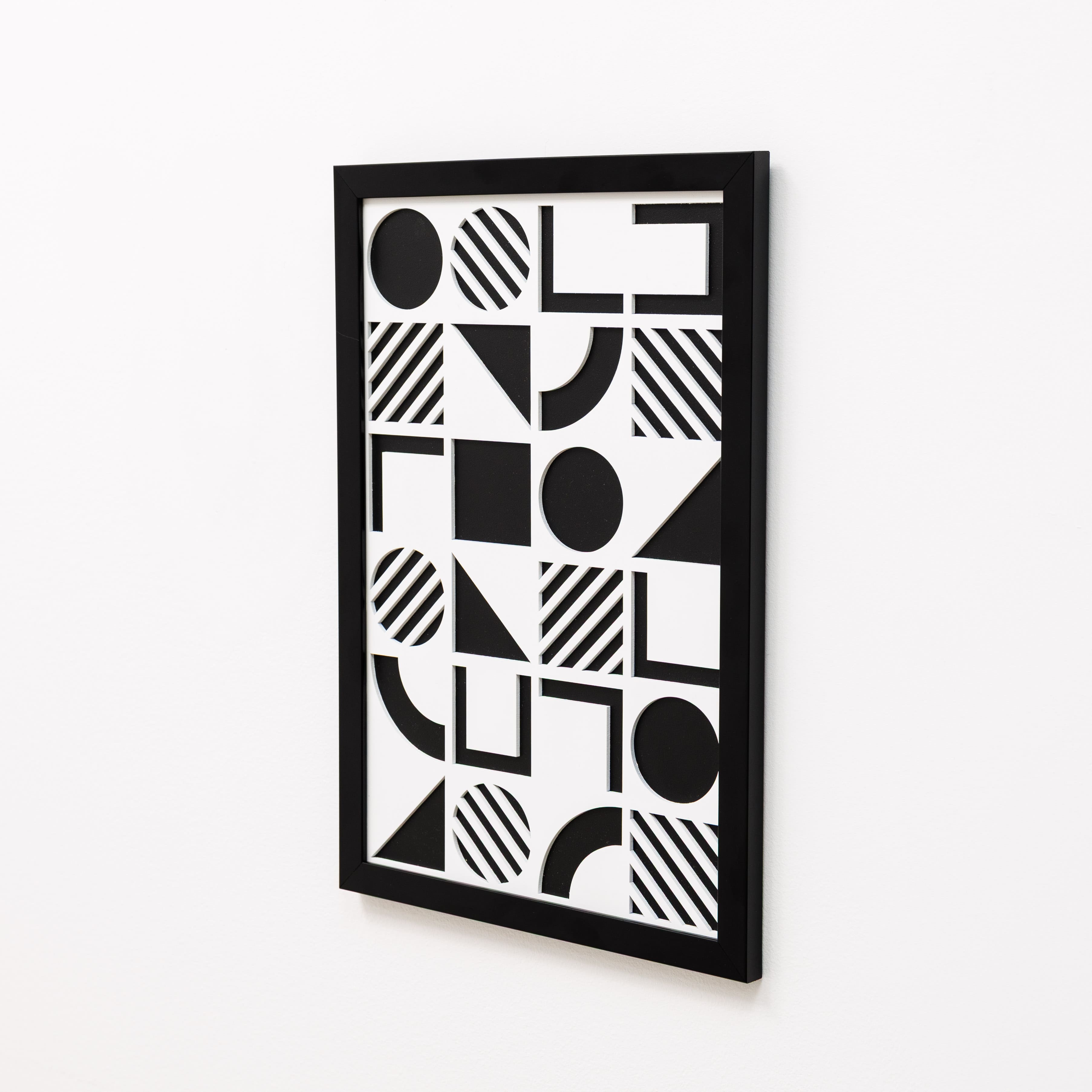 Black and white geometric patterned wall art on a white background
