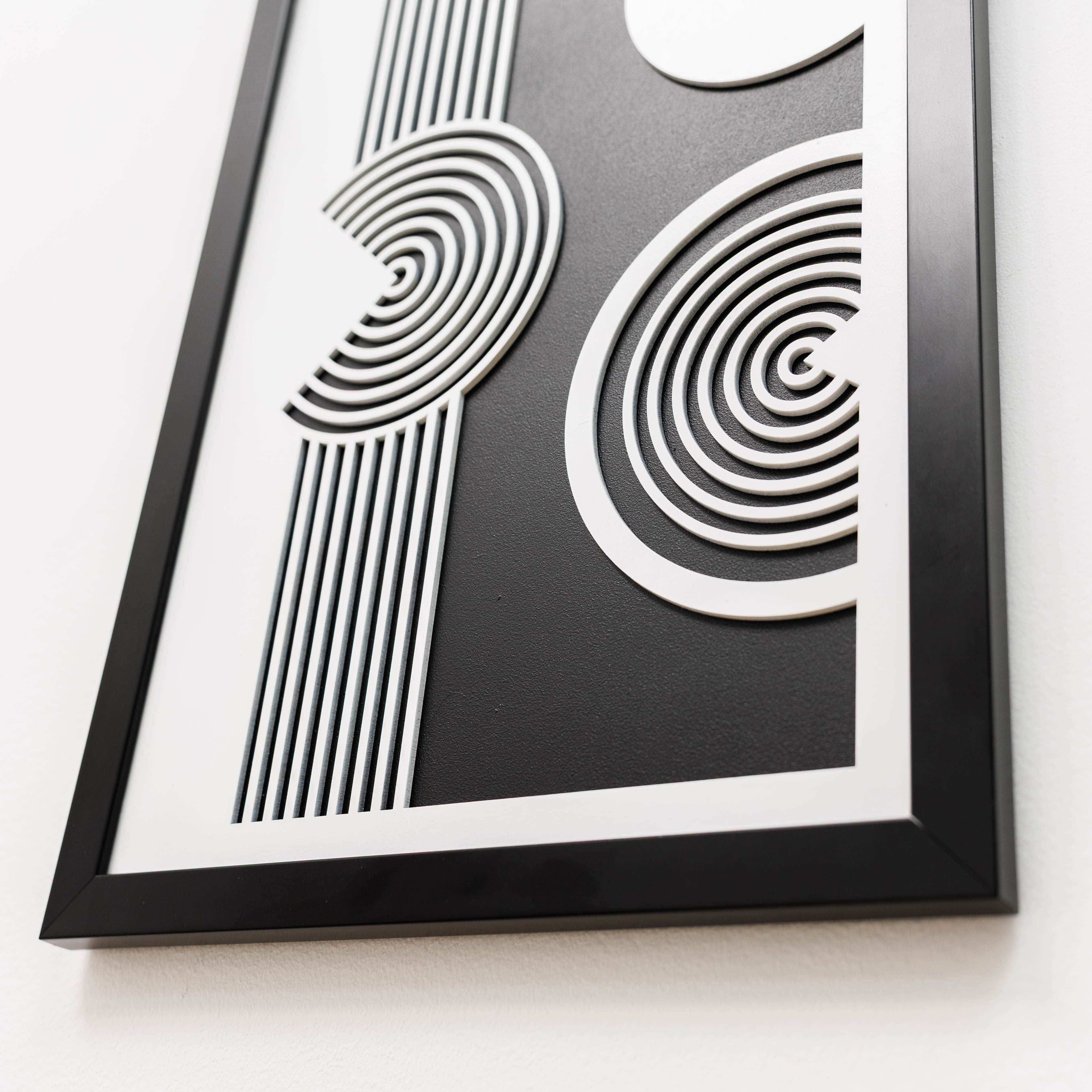 Framed black and white abstract art piece on a white background