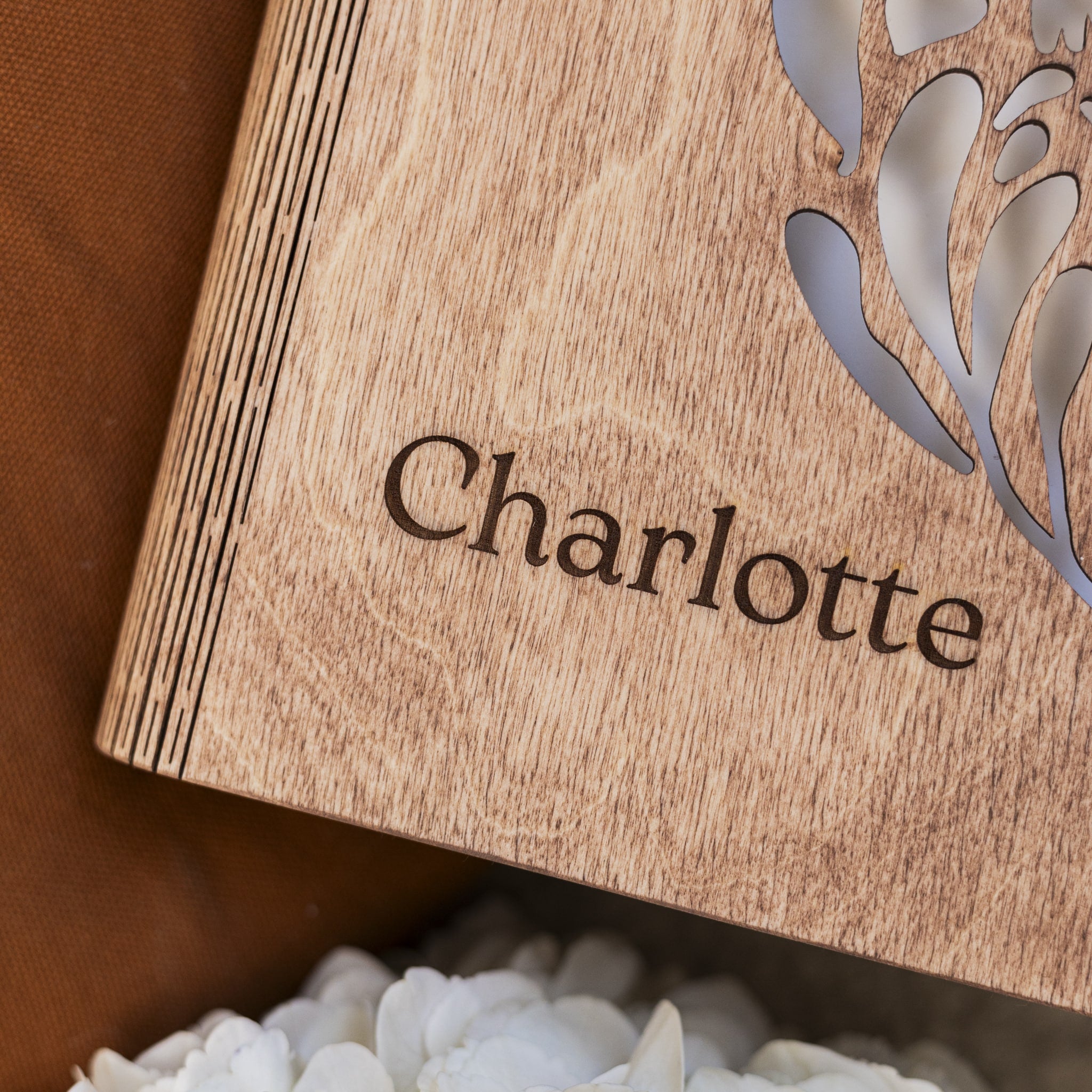 Wooden box with 'Charlotte' engraved on it, featuring a floral cutout design.