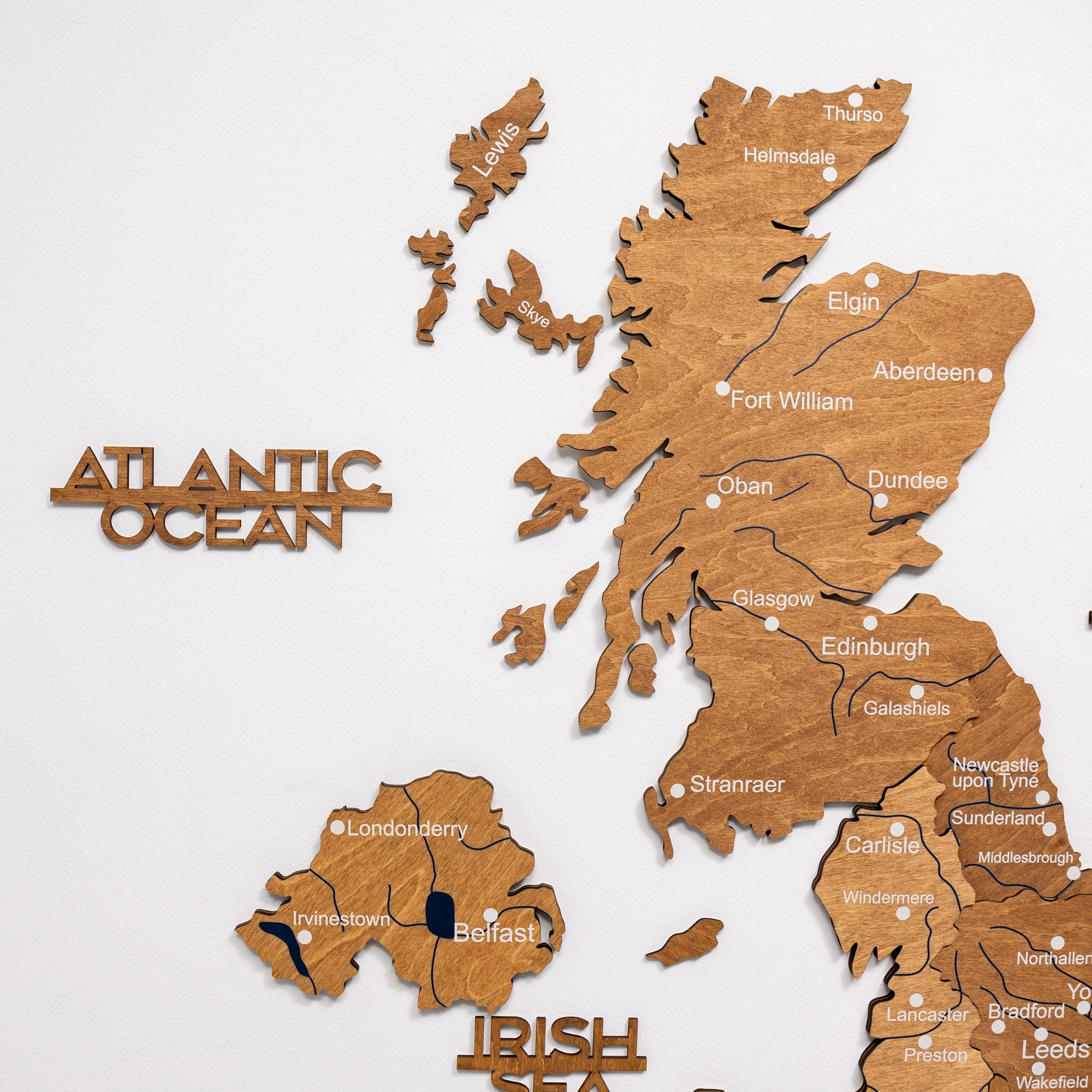 Wooden map of Scotland with cities labeled on a white background
