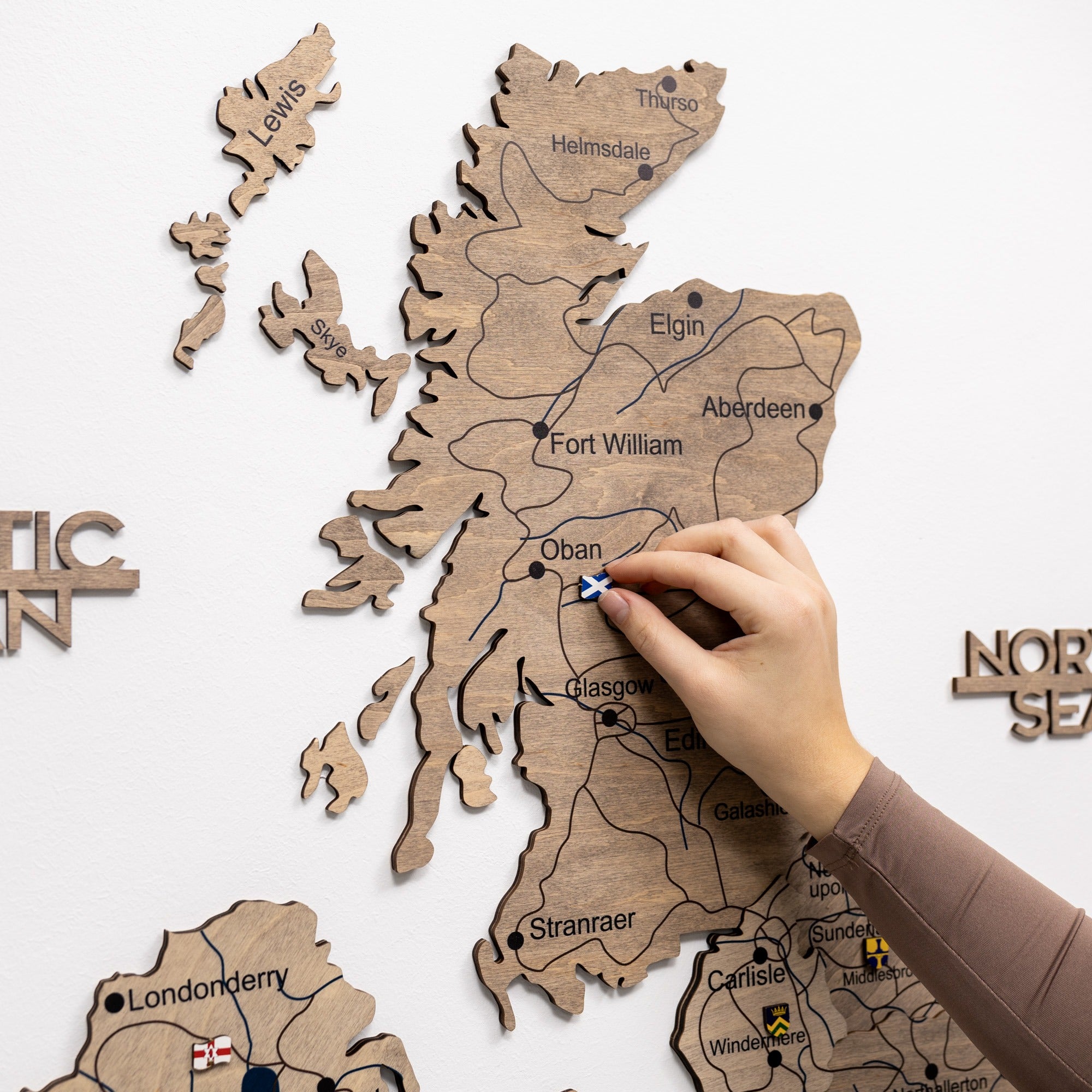 Wooden map of Scotland with a hand pointing to Fort William