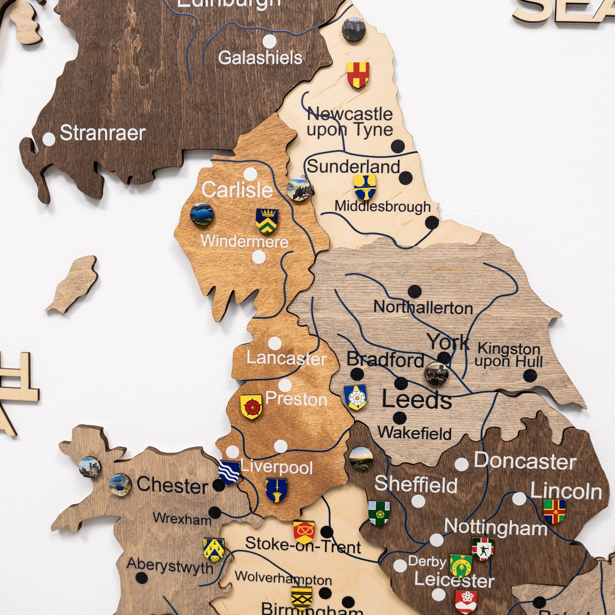 Wooden map of the United Kingdom with cities labeled and flags.