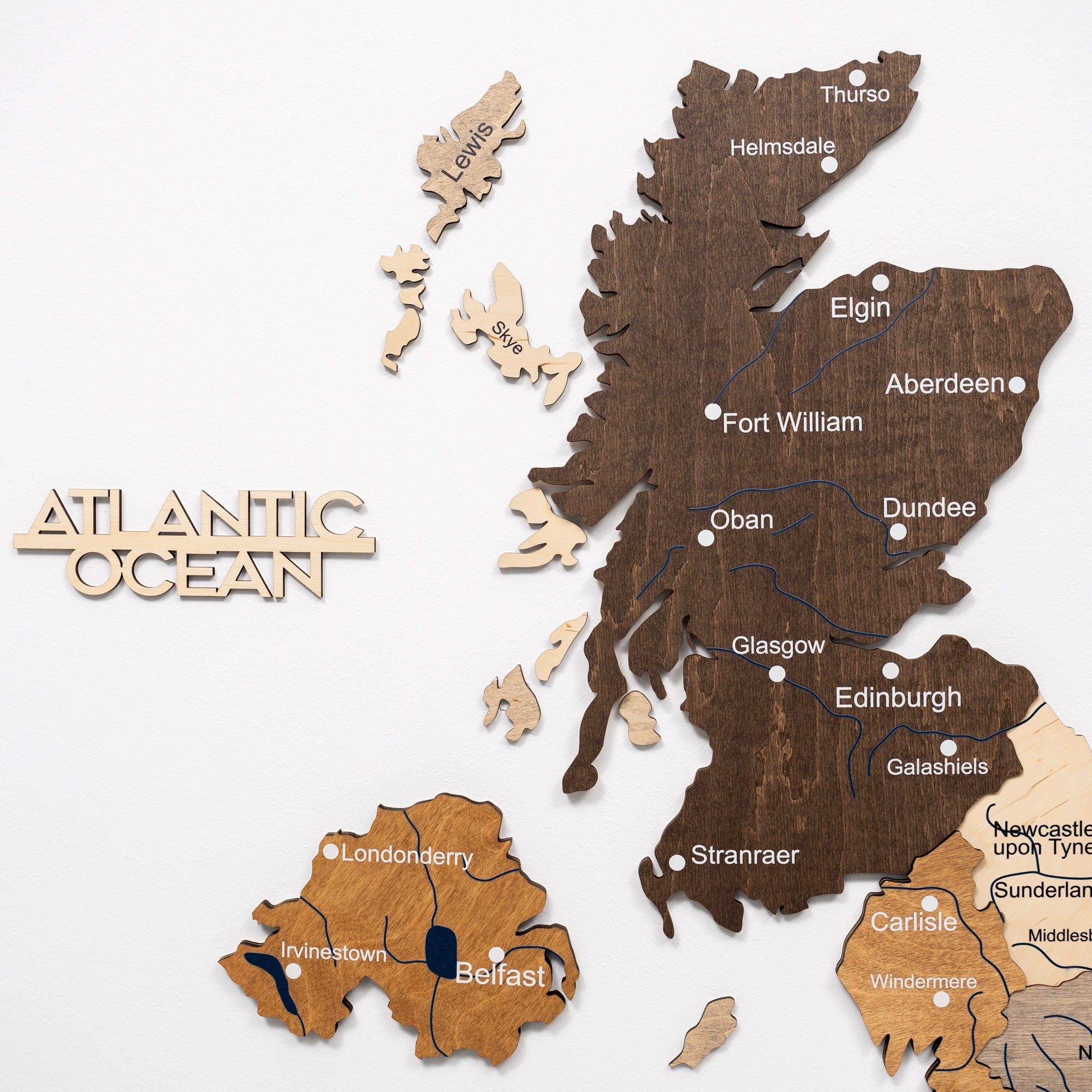 Wooden map of Scotland with cities labeled on a white background