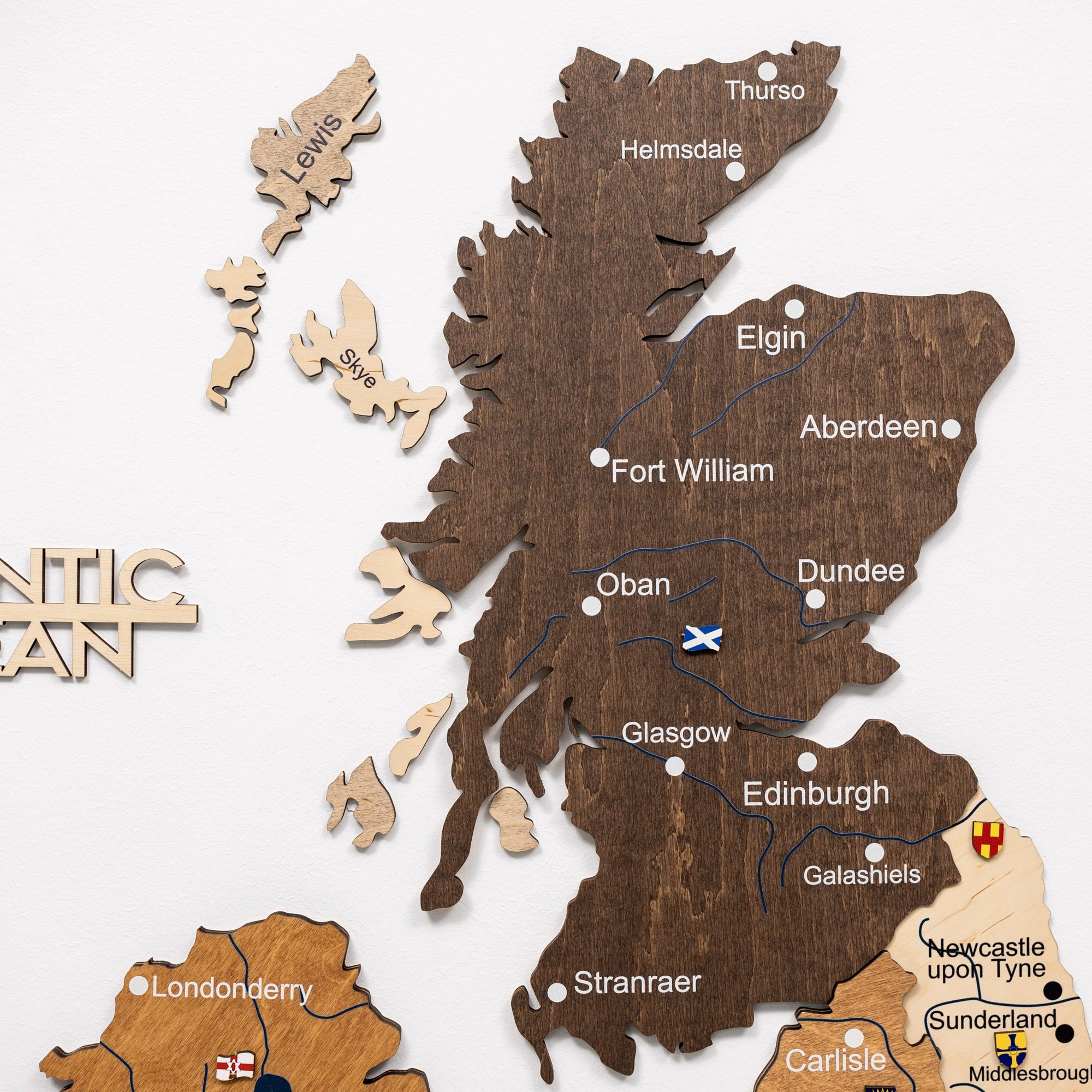 Wooden puzzle map of Scotland with cities labeled on a white background
