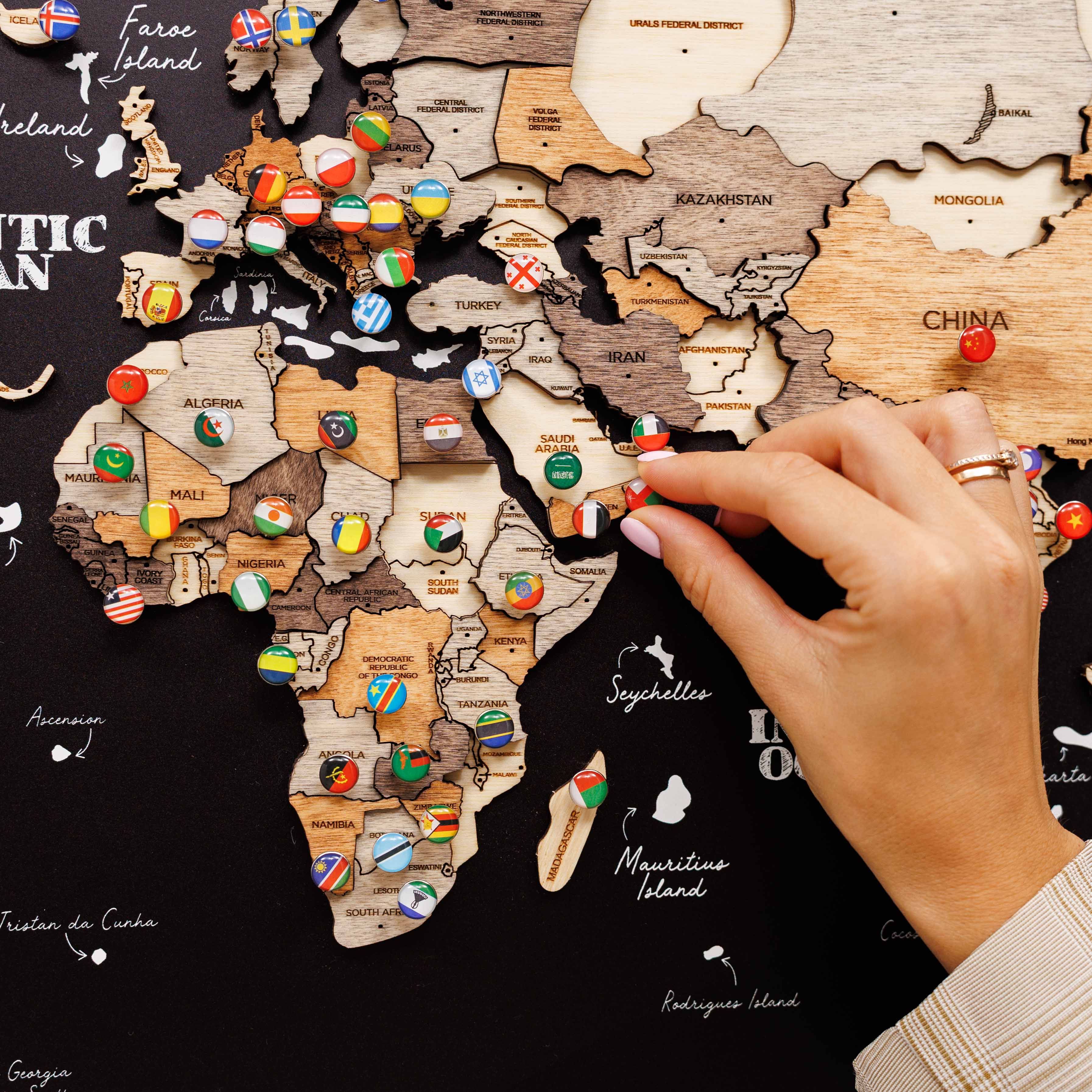 Woman interacting with a world map poster on a wall