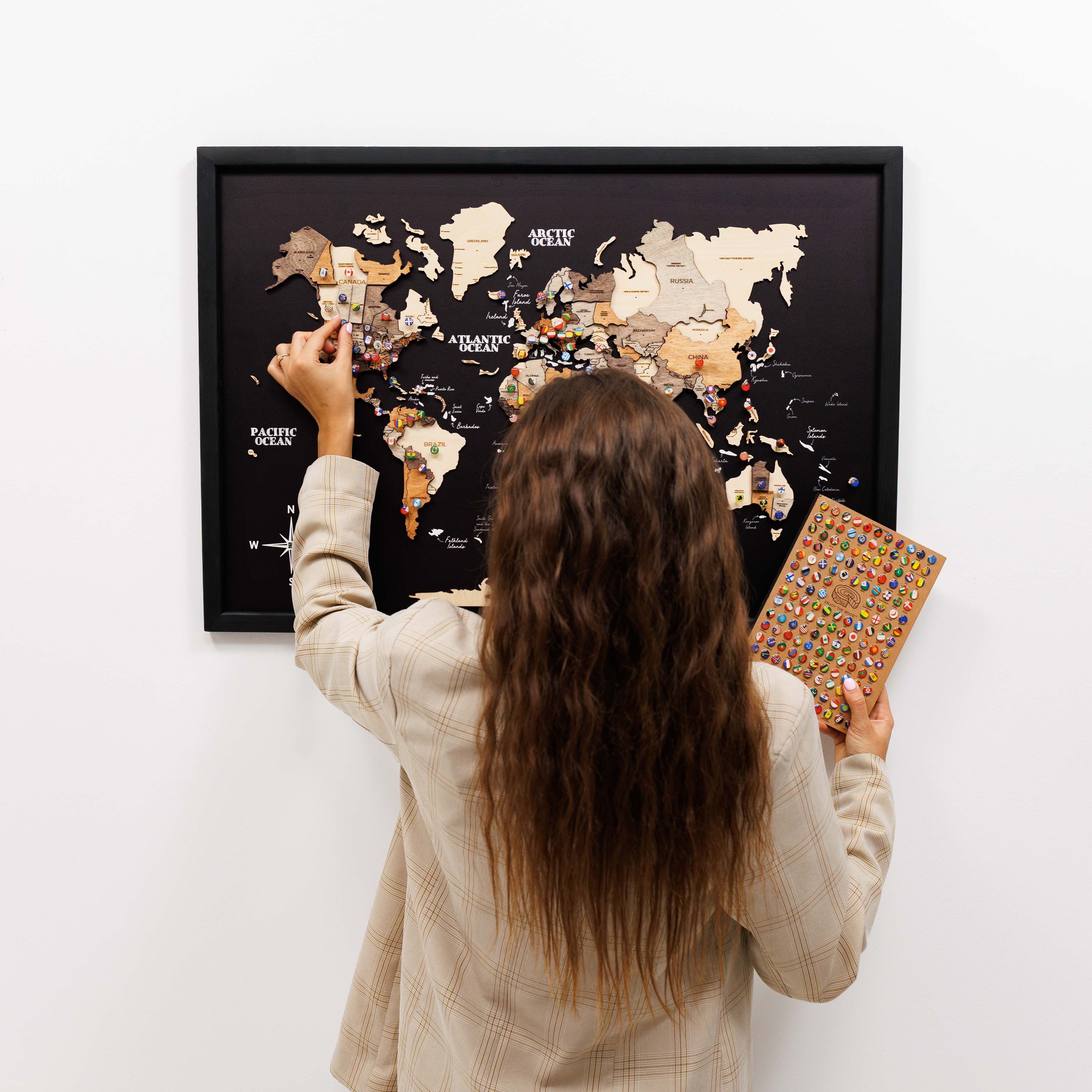 Person assembling a world map puzzle on a wall