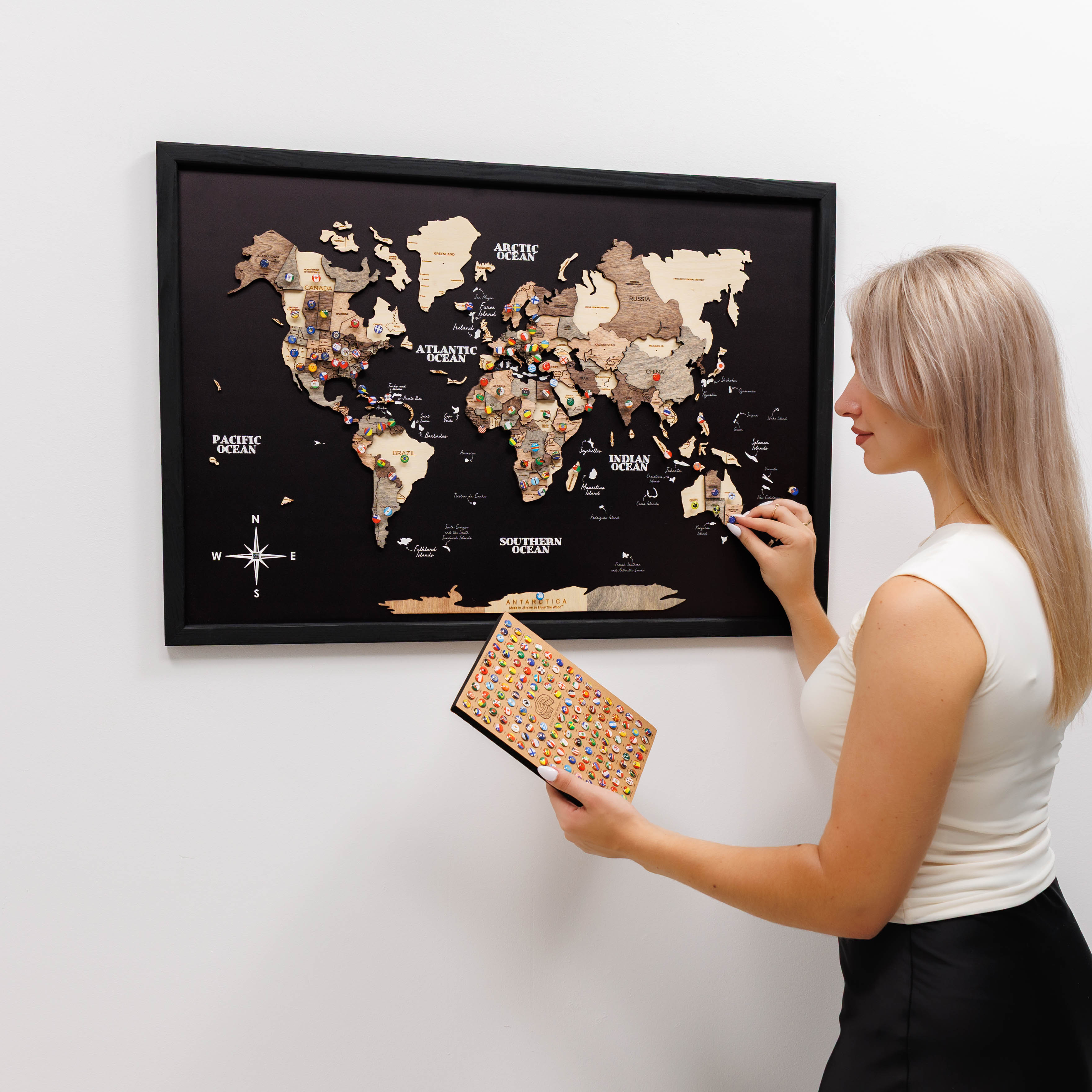 Woman pointing at a framed world map on a wall