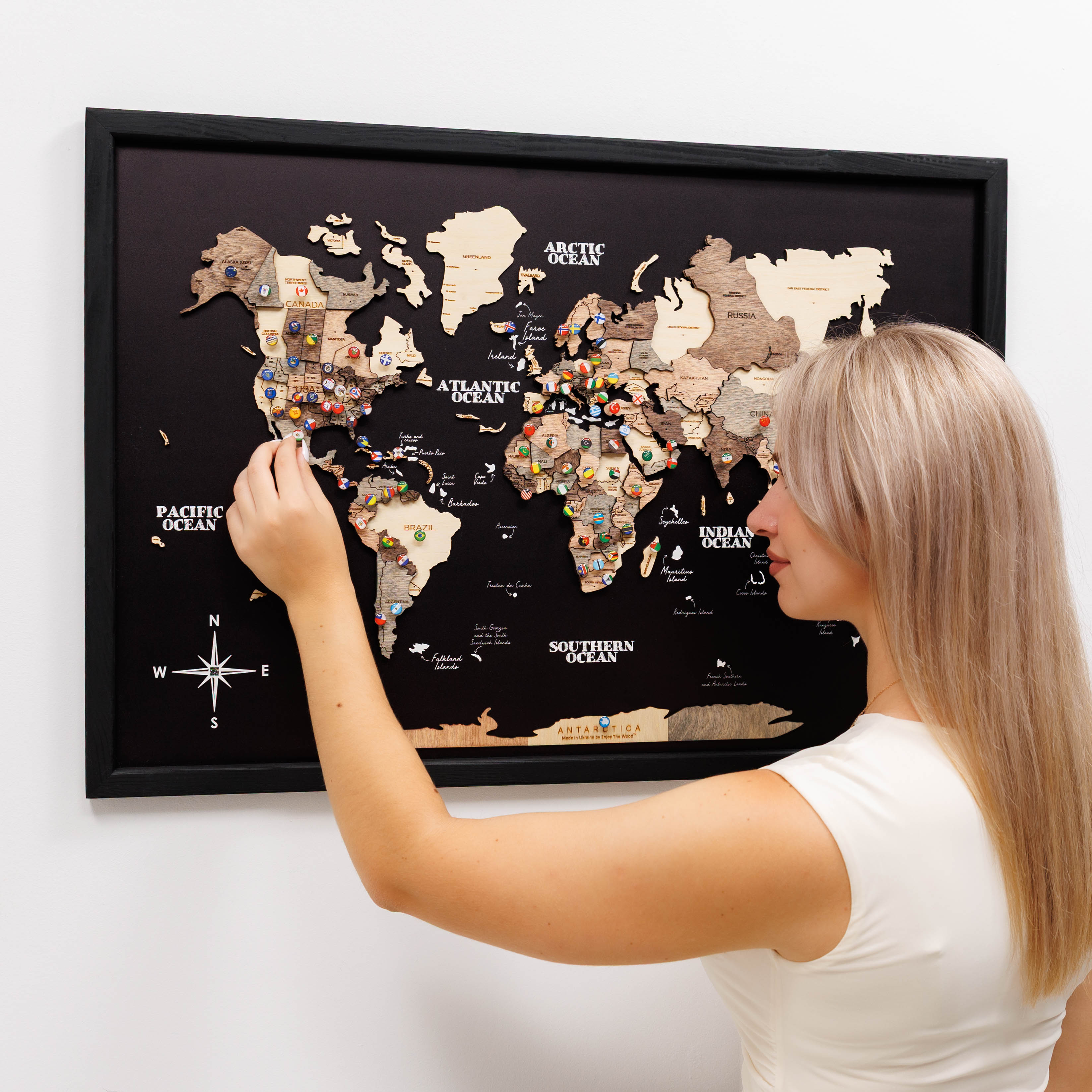 Woman interacting with a world map poster on a wall