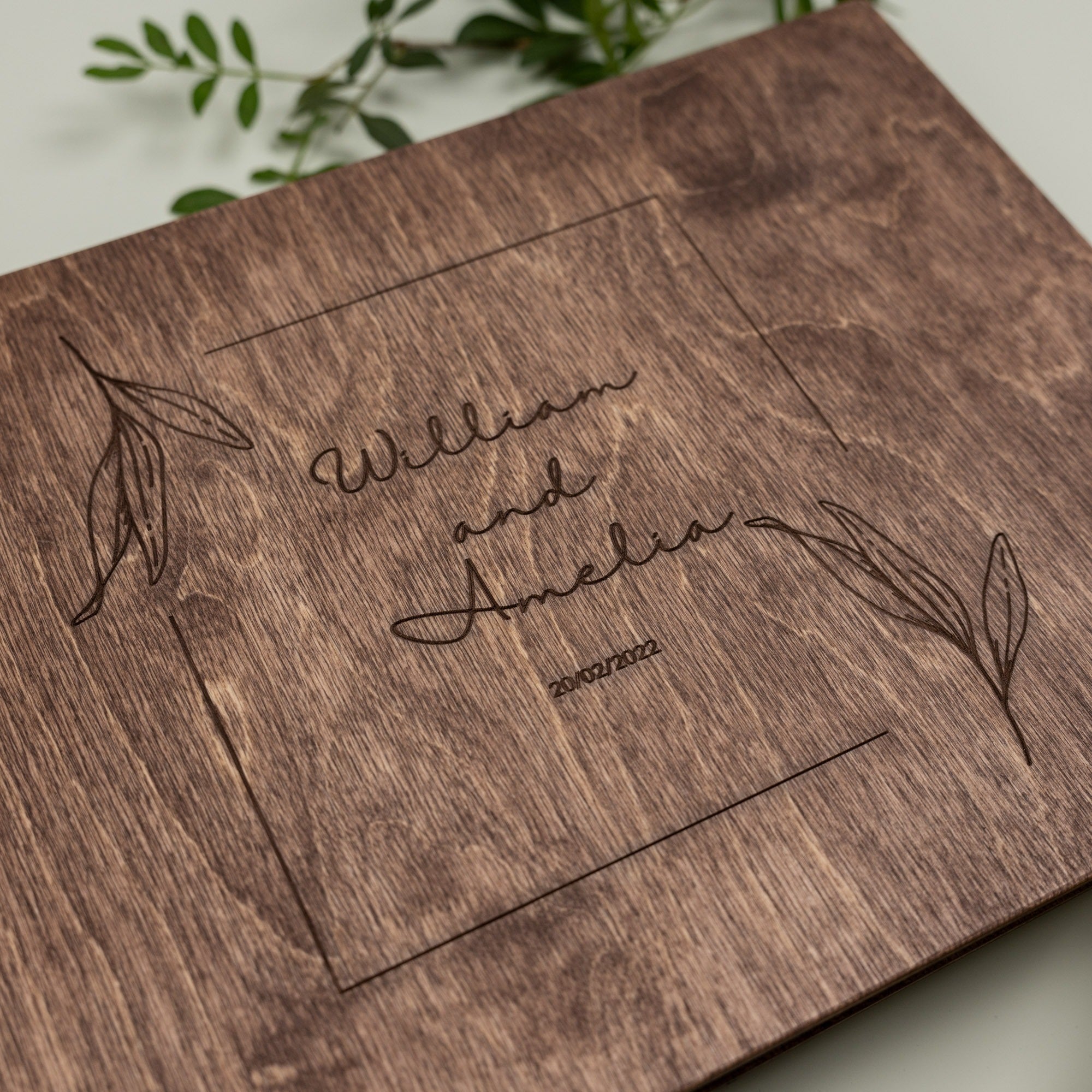 Wooden box with engraved text 'William and Amelia 2022' on a light background