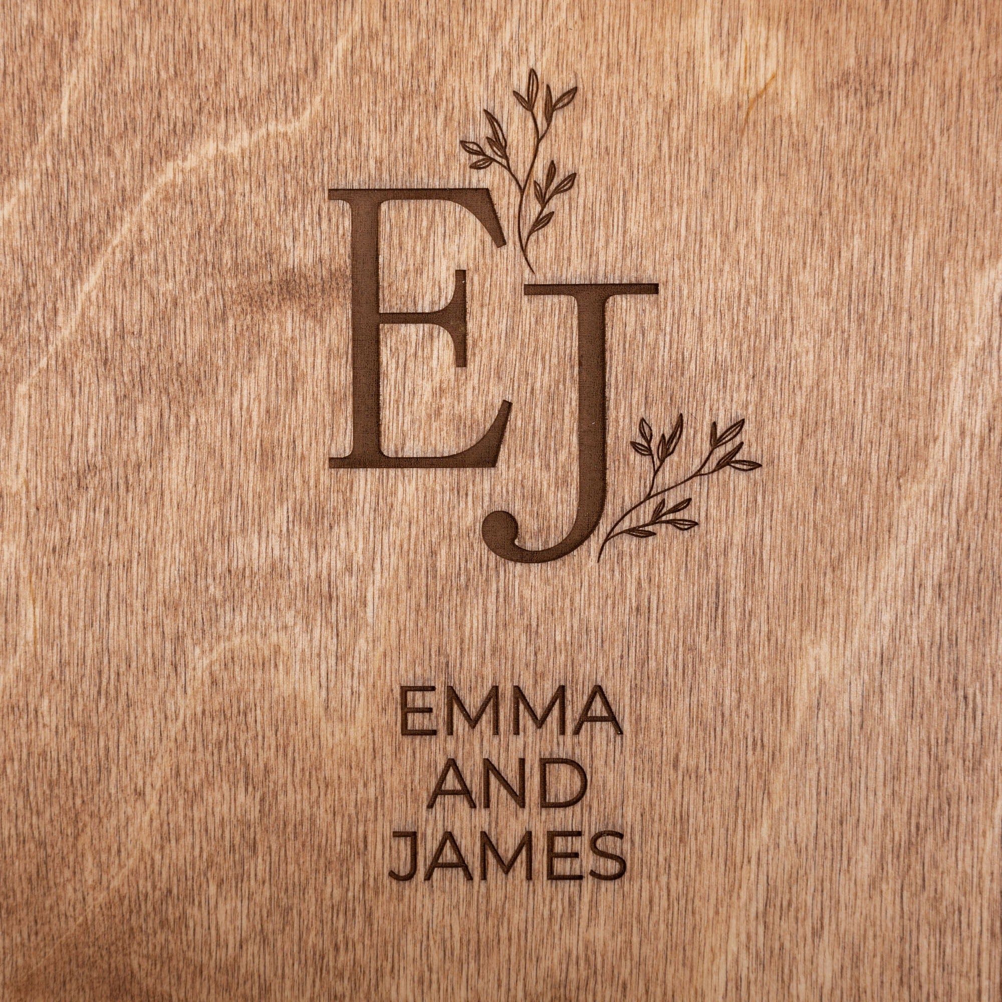 Wooden surface with engraved initials 'EJ' and names 'Emma and James'.